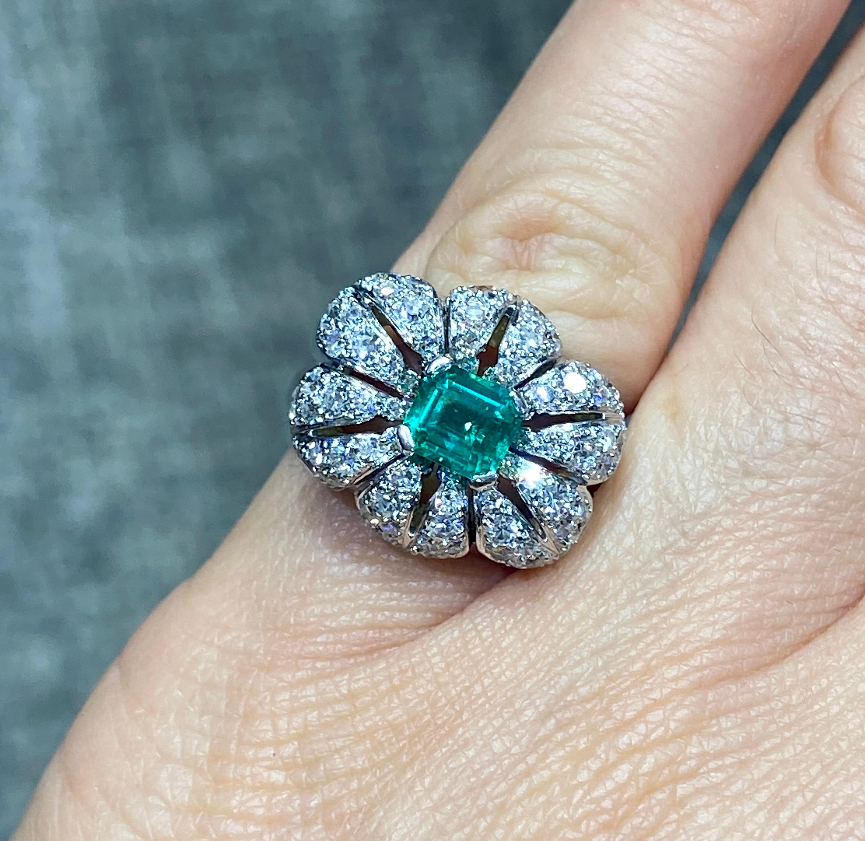 This striking 1950s Cartier cocktail ring centres its design around a beautiful emerald cut 0.8 carat Colombian emerald, the colour of which is quite remarkable. The emerald is adorned with approximately 1.3 carats round cut diamonds. The ring is US