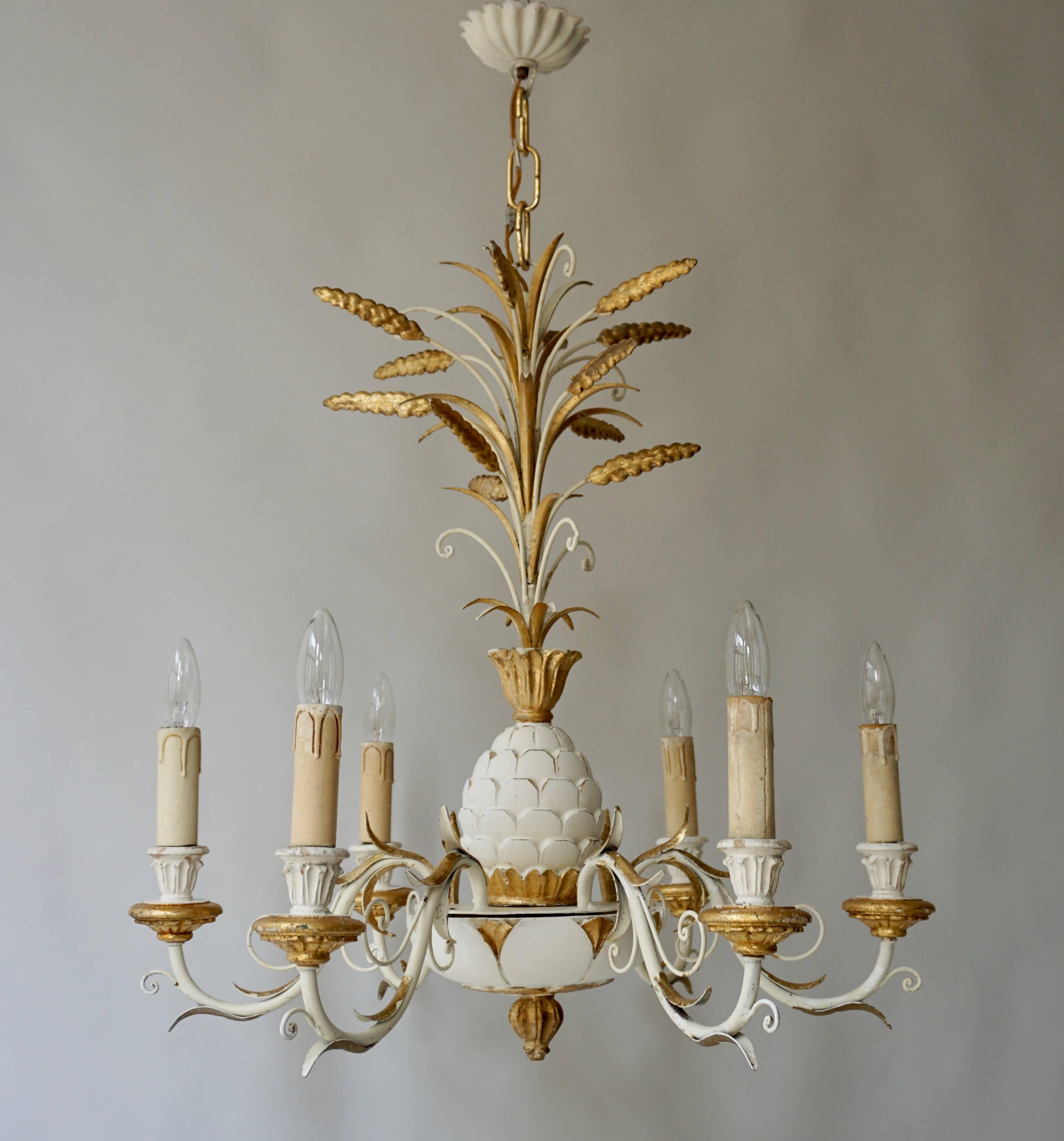 Remarkably vintage carvings, gold gilt and white pineapple decorated Italian chandelier ornament.
Article contains six E14 lights, scrolling iron arms with arrow marks, gold leaf and elegant classic shape.
Measures: Diameter 62 cm.
Height fixture 64