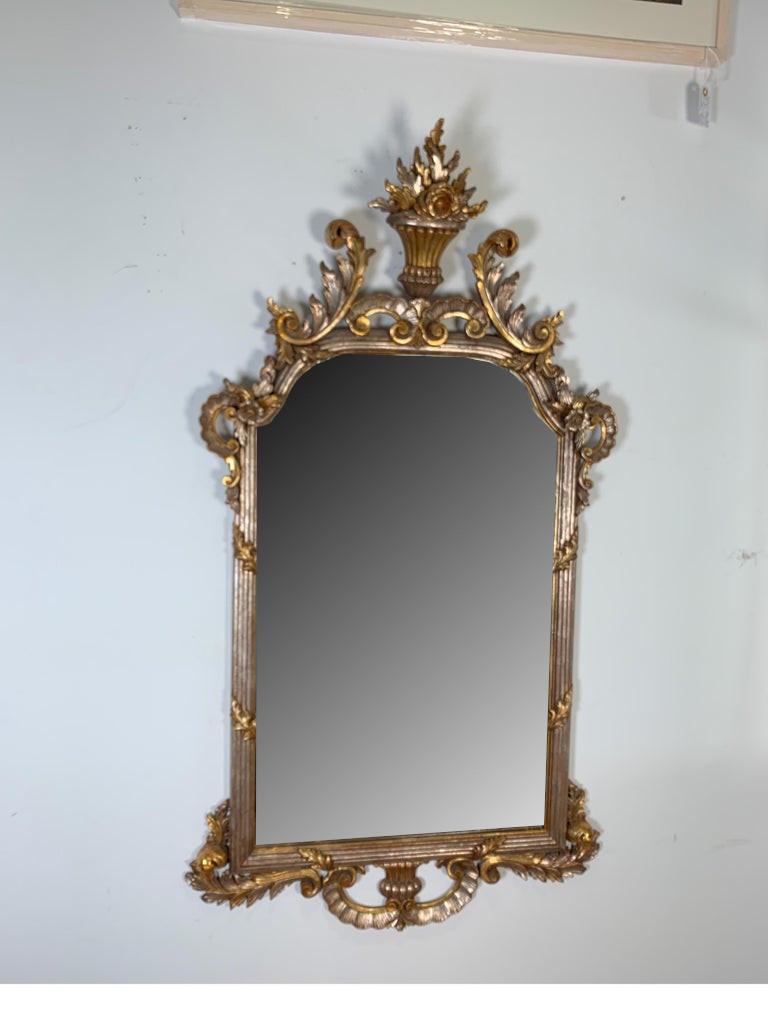 1950s carved Louis XV style silver and gold gilt Italian decorative mirror
The gilt has a nice patina added to give a great look, the top has an urn shape
with flowers flowing from it.
Dimensions: 31