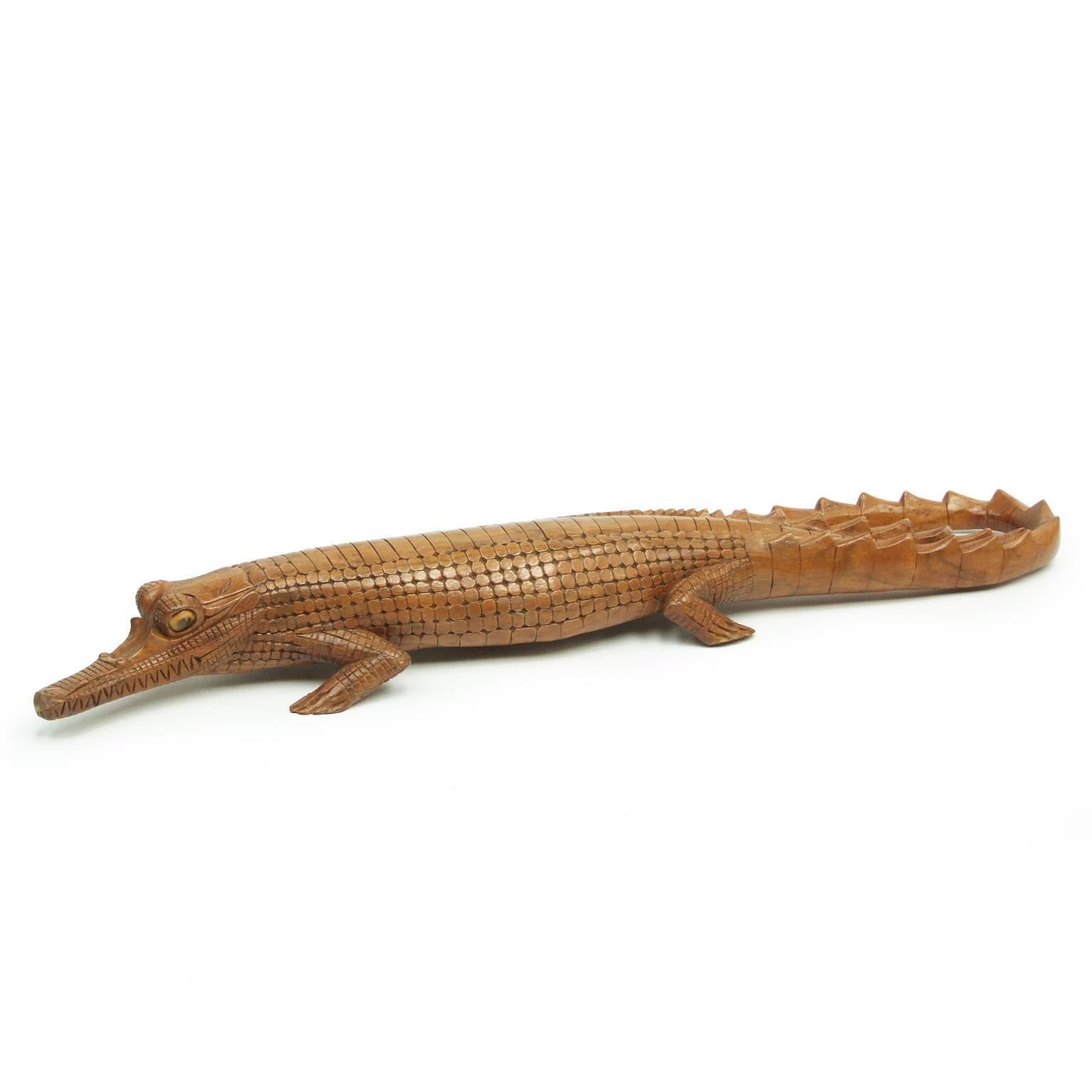 1950s South American carved crocodile.

Detailed fruitwood figure with glass inset eyes.

Measures: H 9cm x L 77cm x W 13cm.