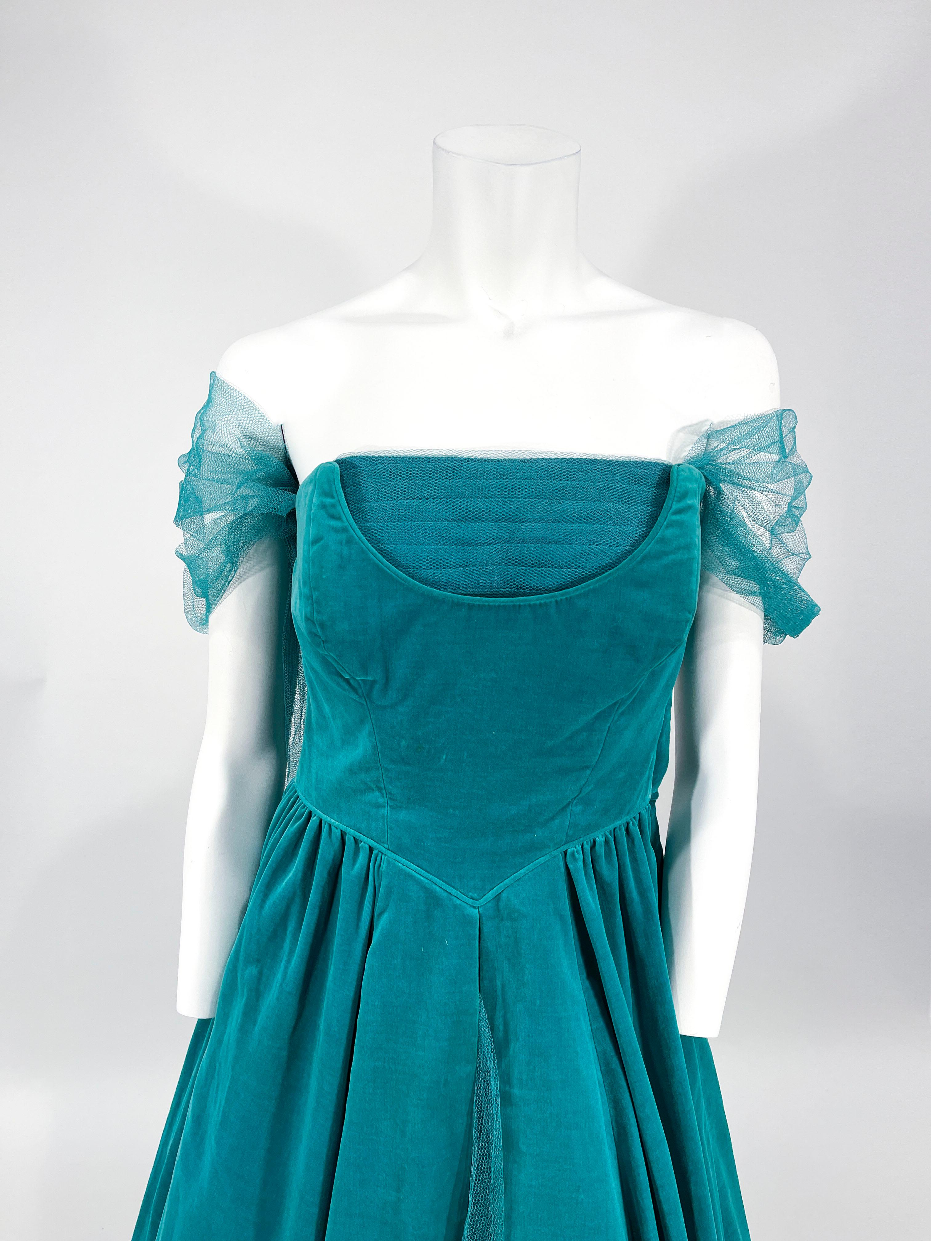 Robe de soirée sans manches en velours de coton vert caselton, longueur thé, faite sur mesure dans les années 1950, avec une encolure modifiée ornée d'un panneau de tulle plissé. Attaché à l'encolure, un pastel de tulle se porte drapé sur les bras