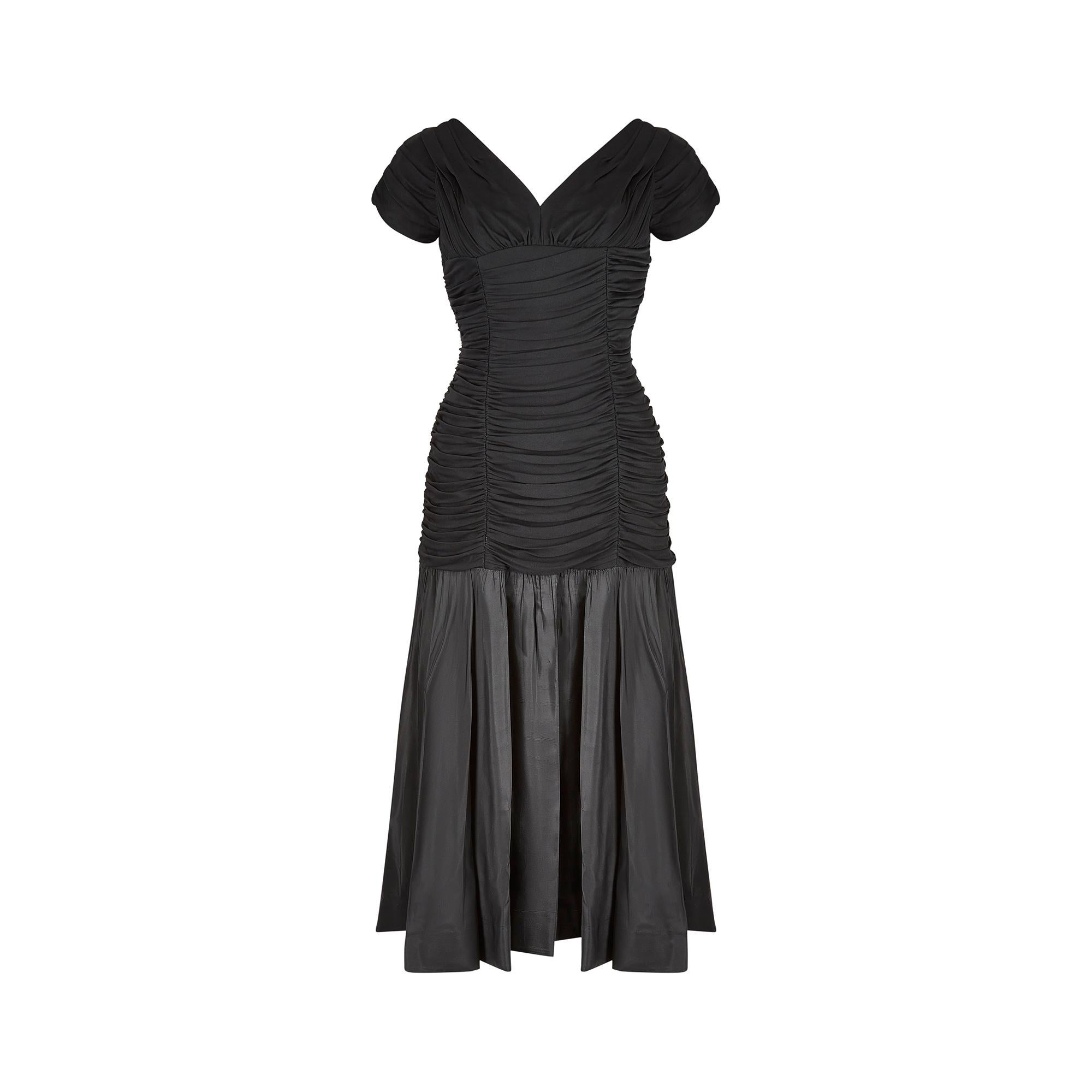 This early 1950s Ceil Chapman taffeta and silk dress is a timeless and elegant party dress. It has a fitted ruched bodice, cut from soft black silk jersey, which hugs the body beautifully to create a feminine shape. The ruching is sewn in two