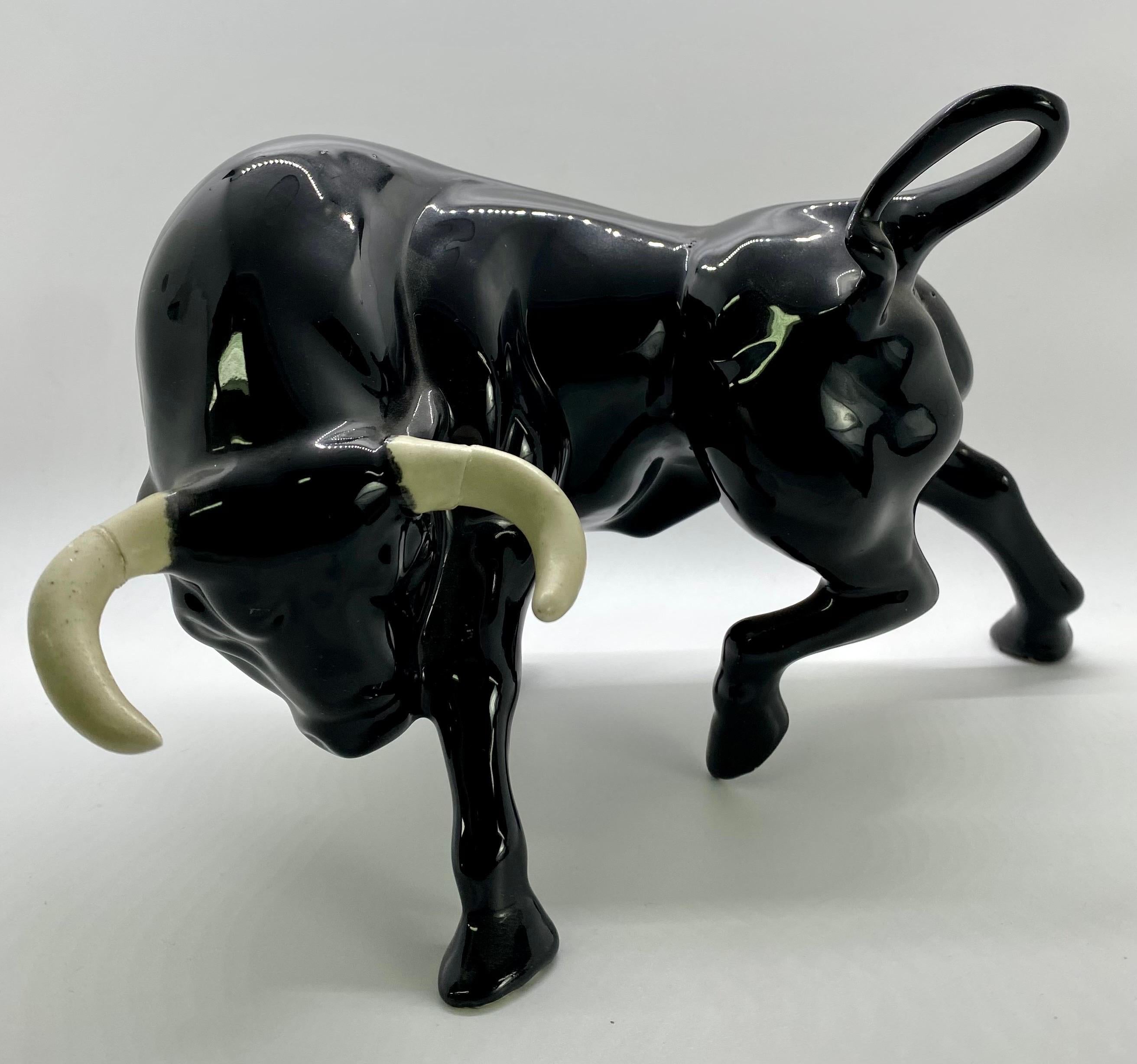An exquisite pair of Mid-Century Modern figurines of two black bulls with white horns made of ceramics. One bull is looking up, the other one is looking down. The bulls are symbols of growth, positivity and optimism. 

Facing Down Bull Dimensions: