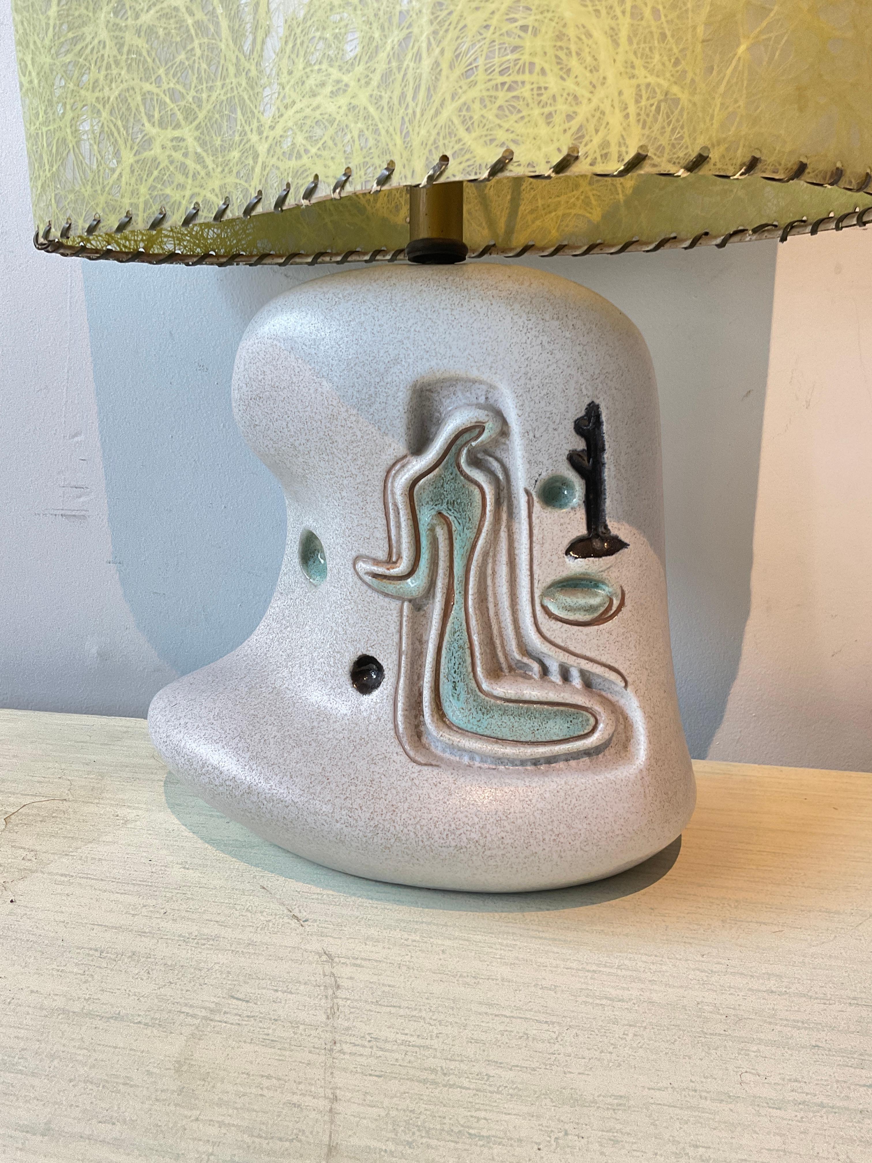 1950s Ceramic lamp with fiberglass shade. Lamp measurements are with the shade on. Shade has some lace missing. 
Lamp needs to be rewired, when rewired, a rod needs to be placed in the lamp .