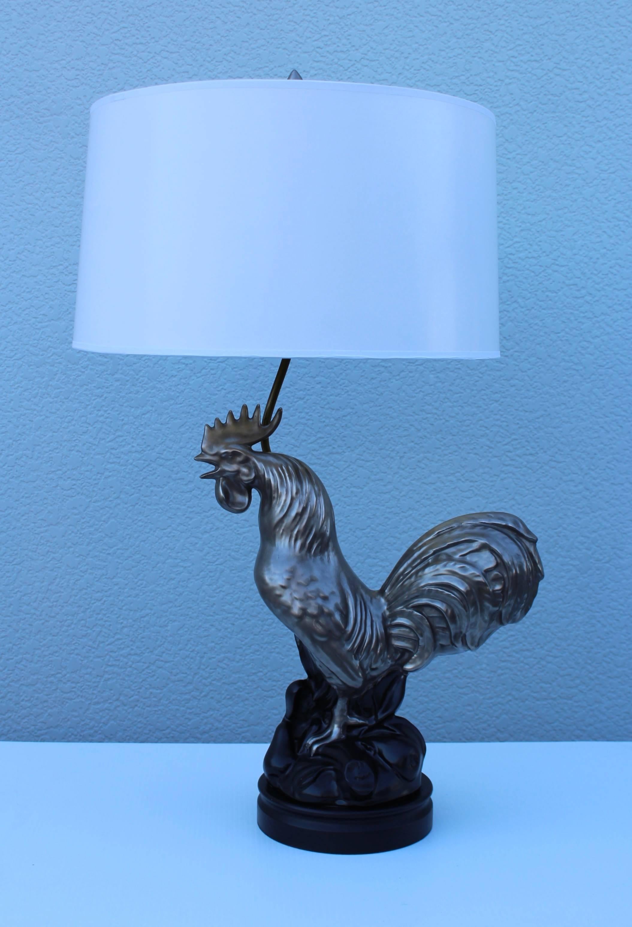 1950s silver ceramic rooster table lamp, with wood base and brass hardware.

Shape for photography only.