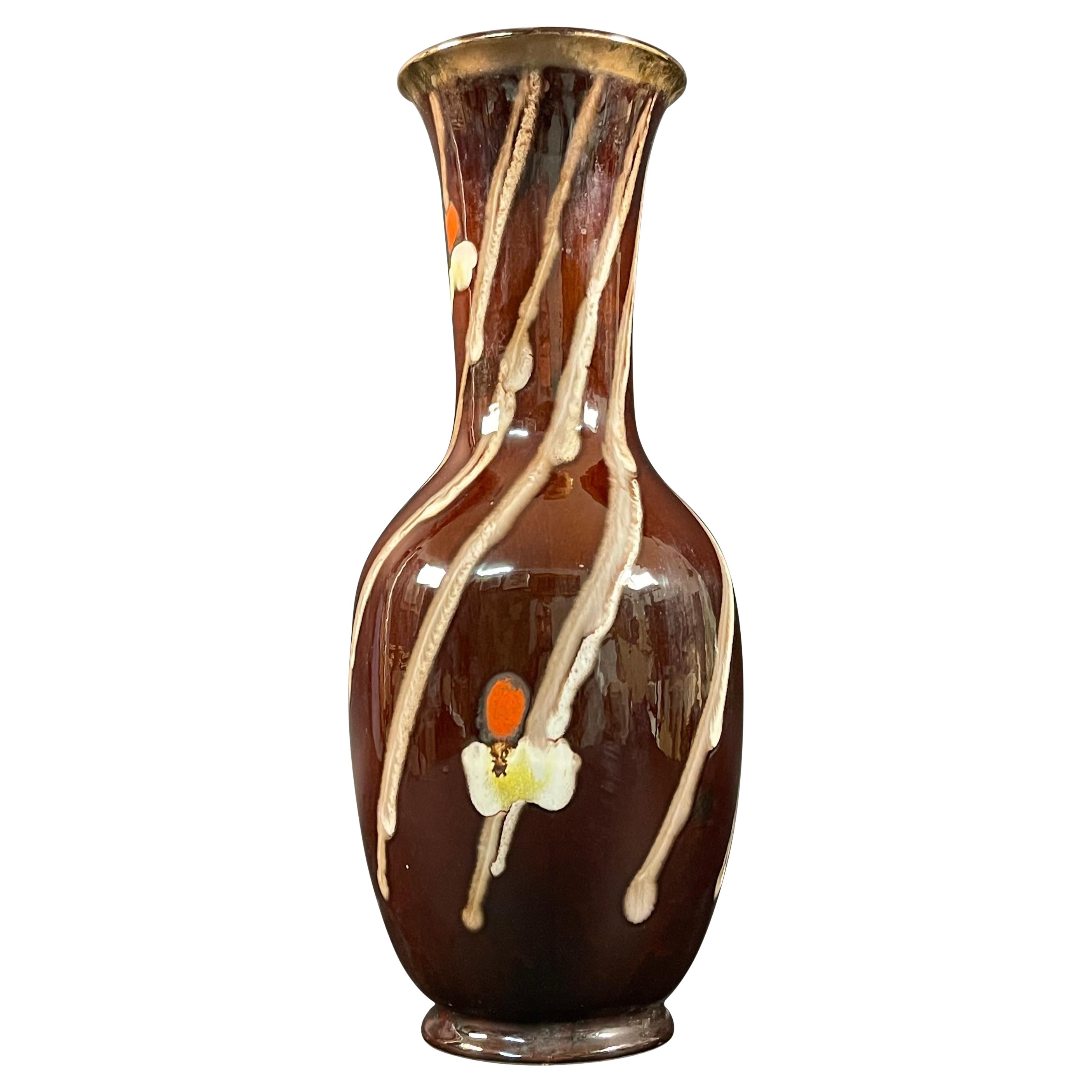 Vase en céramique des années 1950 peint à la main et signé

Beau et élégant vase en céramique émaillée dans les tons de brun avec de belles stries blanches sinueuses. 
Le corps présente de magnifiques motifs floraux peints à la main.
Signé sous la