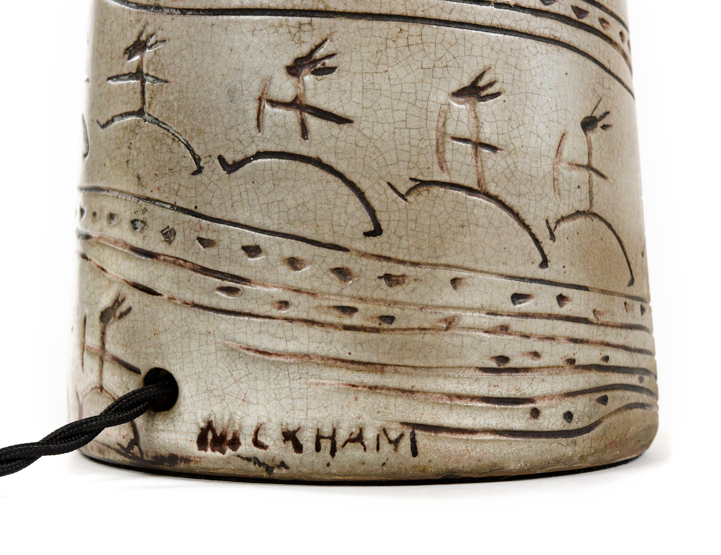A beige and brown ceramic table lamp with incised decoration, signed 'Wickham,' with a base height of 17