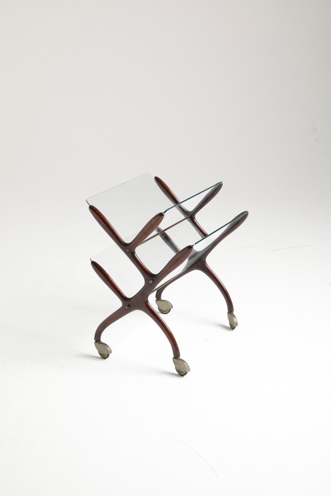 An architectural and elegant magazine rack in wood, glass & brass with four castor wheels designed by Cesare Lacca.



 
