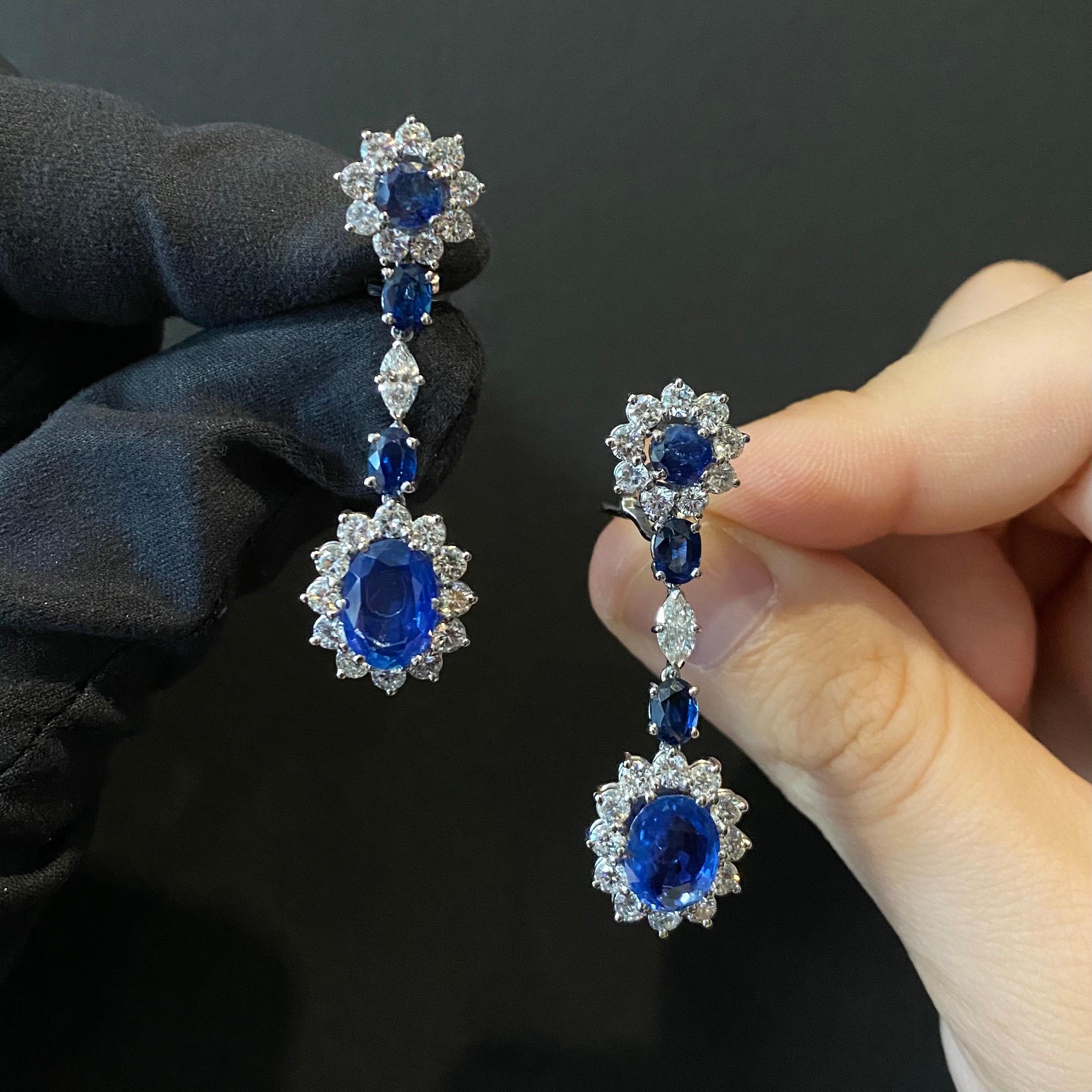 1950s Ceylon Sapphire and Diamond Cluster Drop Earrings in Platinum and White Gold, Portuguese. Each earring is designed as a circular sapphire and round brilliant-cut diamond cluster surmount suspending a larger oval sapphire and round
