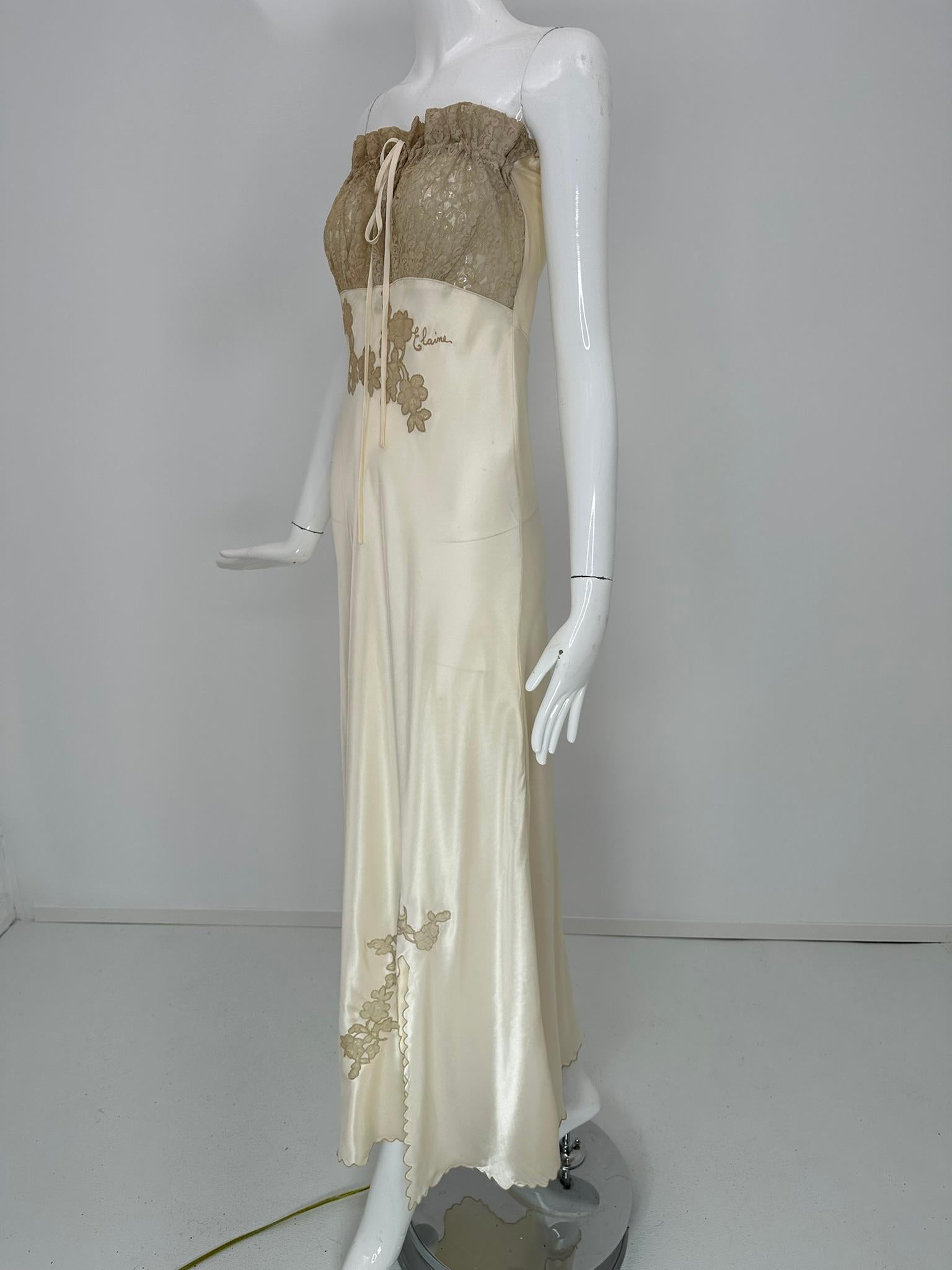 Vestido/camisón de noche de los años 50 de satén de rayón color champán, corte al bies, corpiño de encaje sin tirantes y apliques. Inusual vestido sin tirantes con un corpiño delantero de encaje que tiene un cierre de cordón de satén. El tono