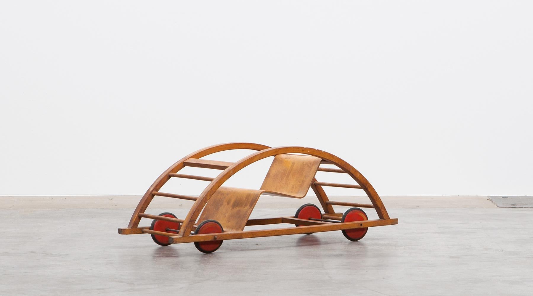 Swing cart, children toy in lacquered red wood and metal, Germany, 1951.

Authentic swing cart from the 1950s, unique in shape and workmanship. Designed by Hans Brockhage, a German designer and sculptor from East Germany. The swing cart can be used