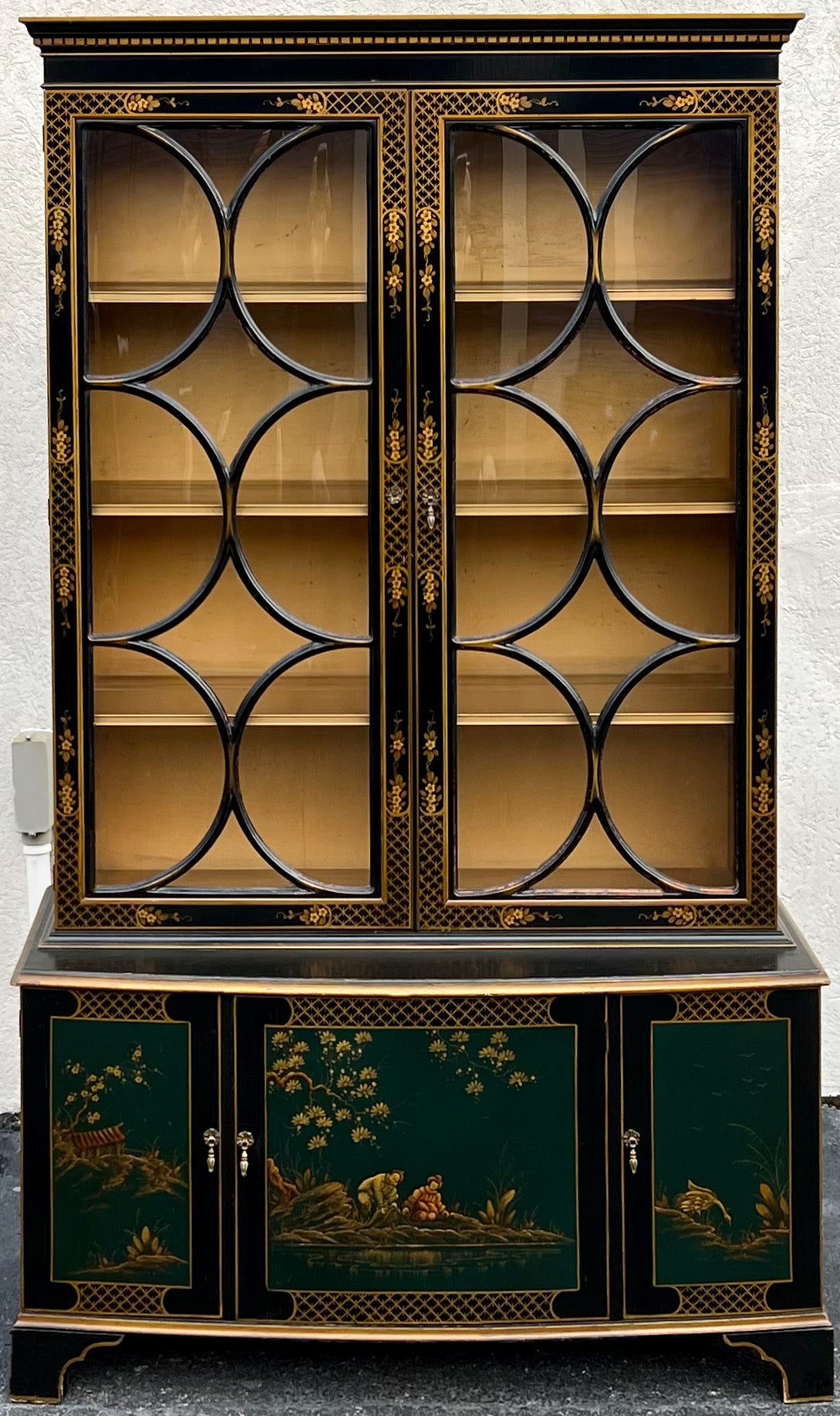 This is a beautiful piece! The size makes it versatile as well. It is one piece. This chinoiserie cabinet has Chinese Chippendale styling and a vibrant gold interior. It appears to be hand painted. The bottom portion has a single shelf. Pastoral