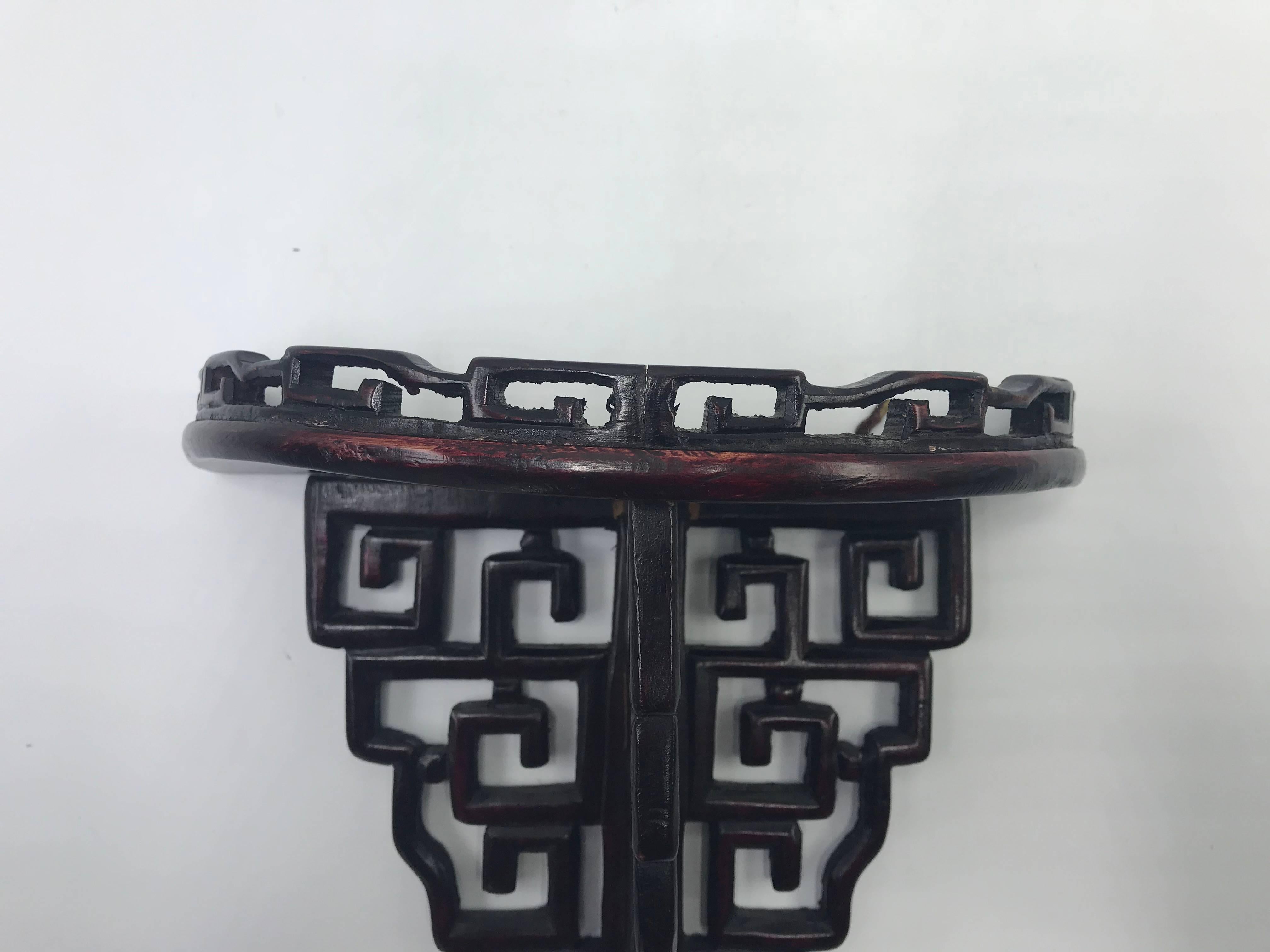 Offered is a stunning, 1950s Chinese rosewood wall shelf bracket. The piece has a gorgeous, Chinoiserie Greek key detailing. Two small rings for mounting along backside.
