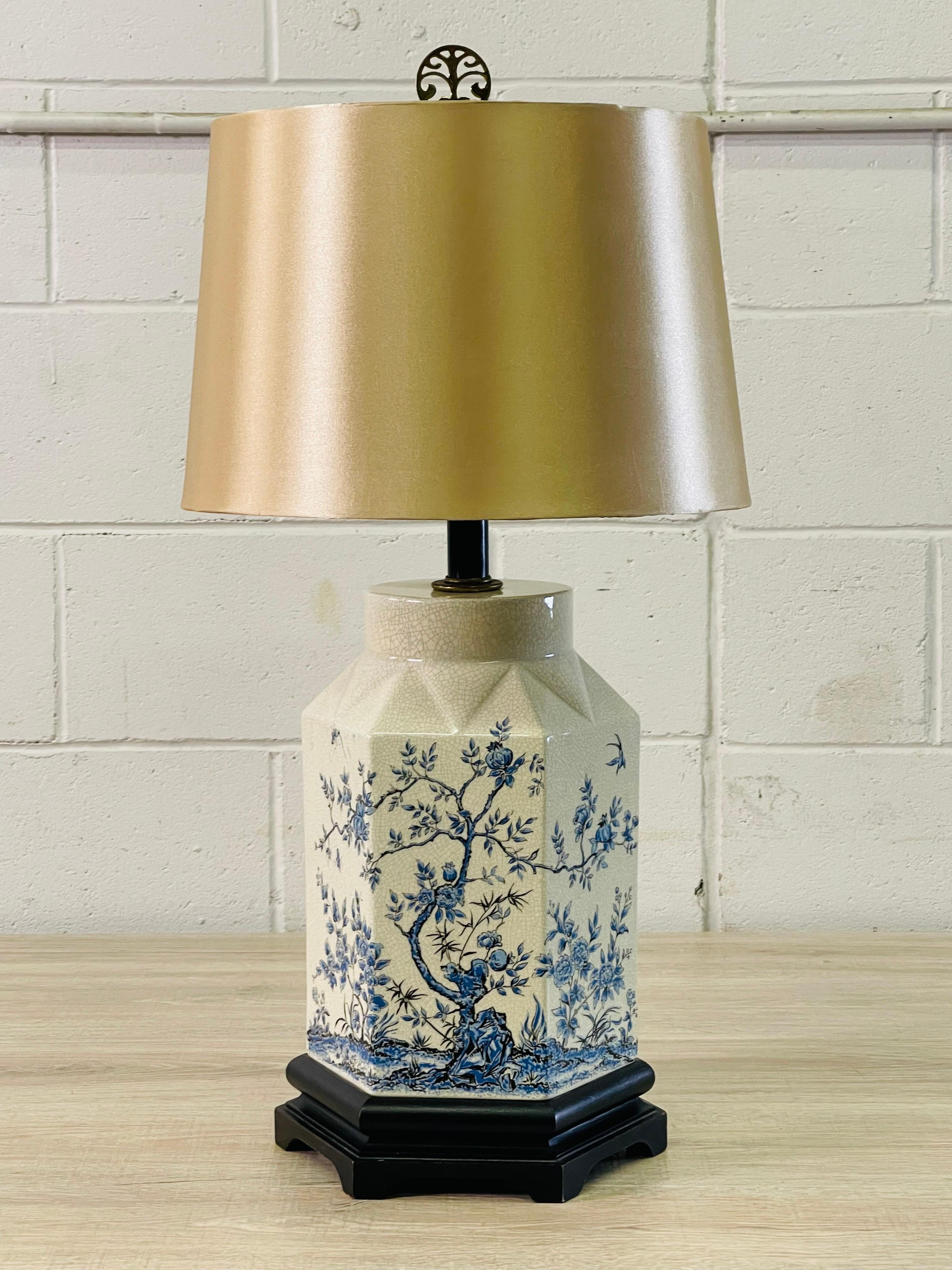 Vintage 1950s Chinoiserie blue and white crackle finish ceramic table lamp. The lamp has a tree and floral design on a mahogany wood base. Wired for the US and in working condition. Socket, 20”H. Harp, 4” diameter x 8” height. No marks. Shade is not