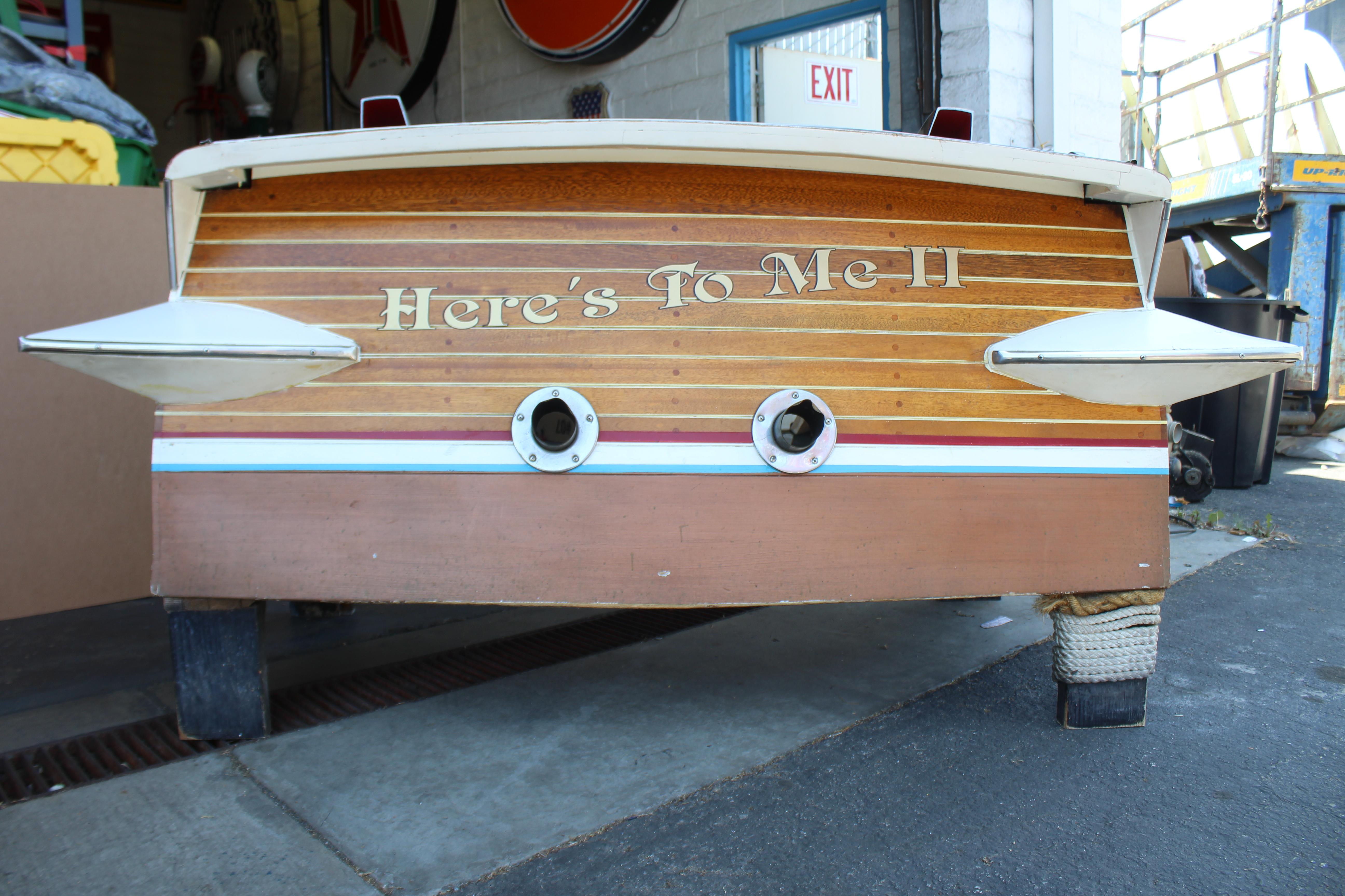 Half of Chris craft boat used as bar back. On wheels for easy moving and can be re purposed for anything else. Has original wear and cracking around the edges. Trim is still intact and emblems on both sides.