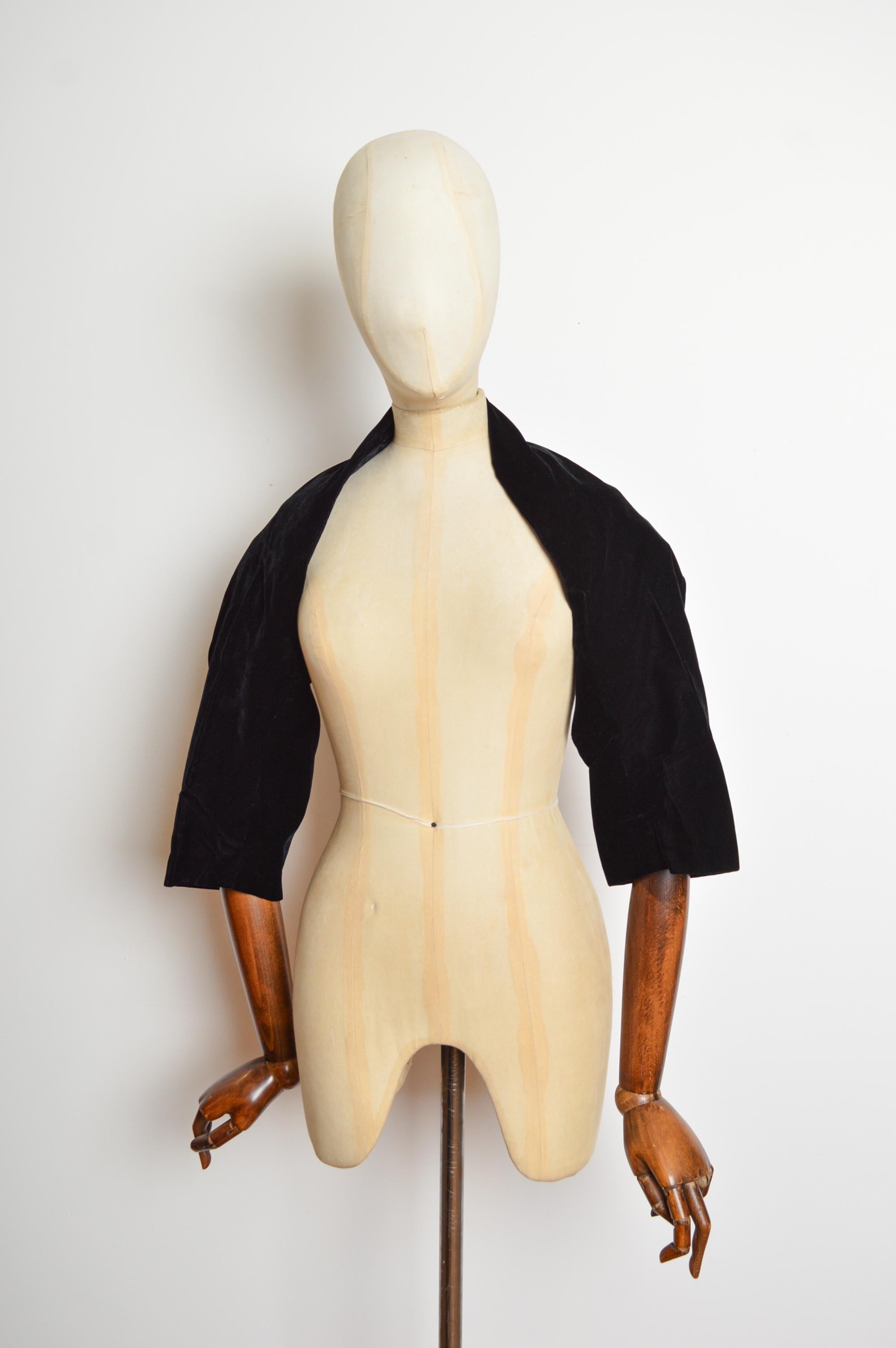 1950's Christian Dior Couture Negro Terciopelo Bolero Estola - Chaqueta Corta Encogida de Hombros
Un Bolero Vintage Christian Dior Couture instantáneamente reconocible, confeccionado en terciopelo negro, con una silueta atemporal en forma de