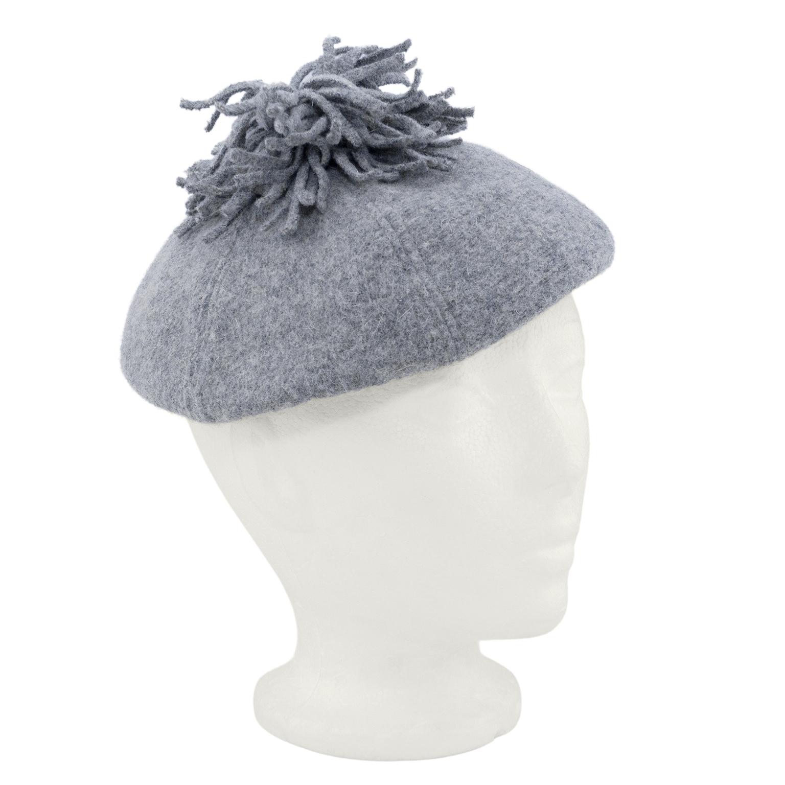Adorable 1950s Christian Dior beret. Grey wool with large saucy fringe pom pom. Cream silk interior with grey grosgrain trim. Fits a small-med head. Excellent vintage condition. License Chapeaux label. 
