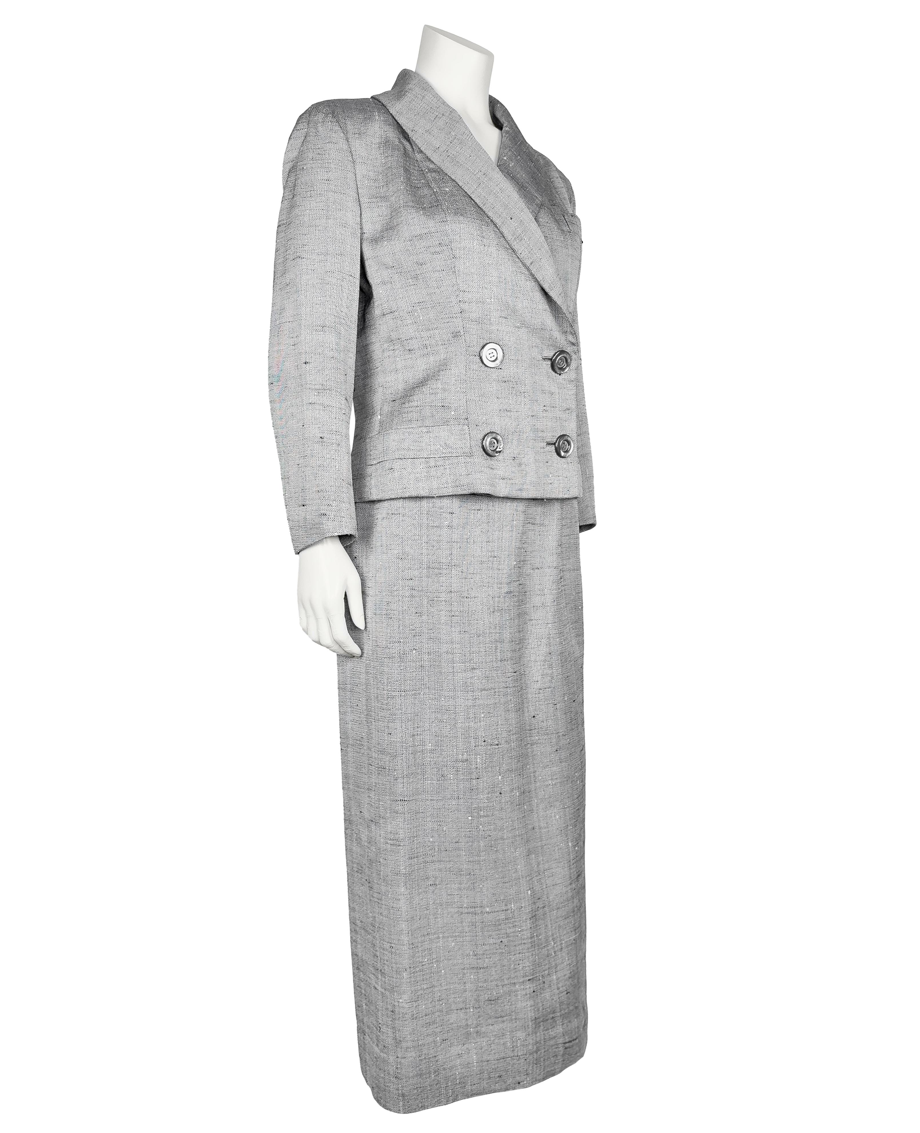 Realizzato in un tessuto di seta grigio con fili bianchi e neri, questo tailleur con gonna a due pezzi risale agli anni '50 e porta l'etichetta Dior New York. Condizioni vintage eccellenti, senza segni di usura visibili. Completamente foderato in