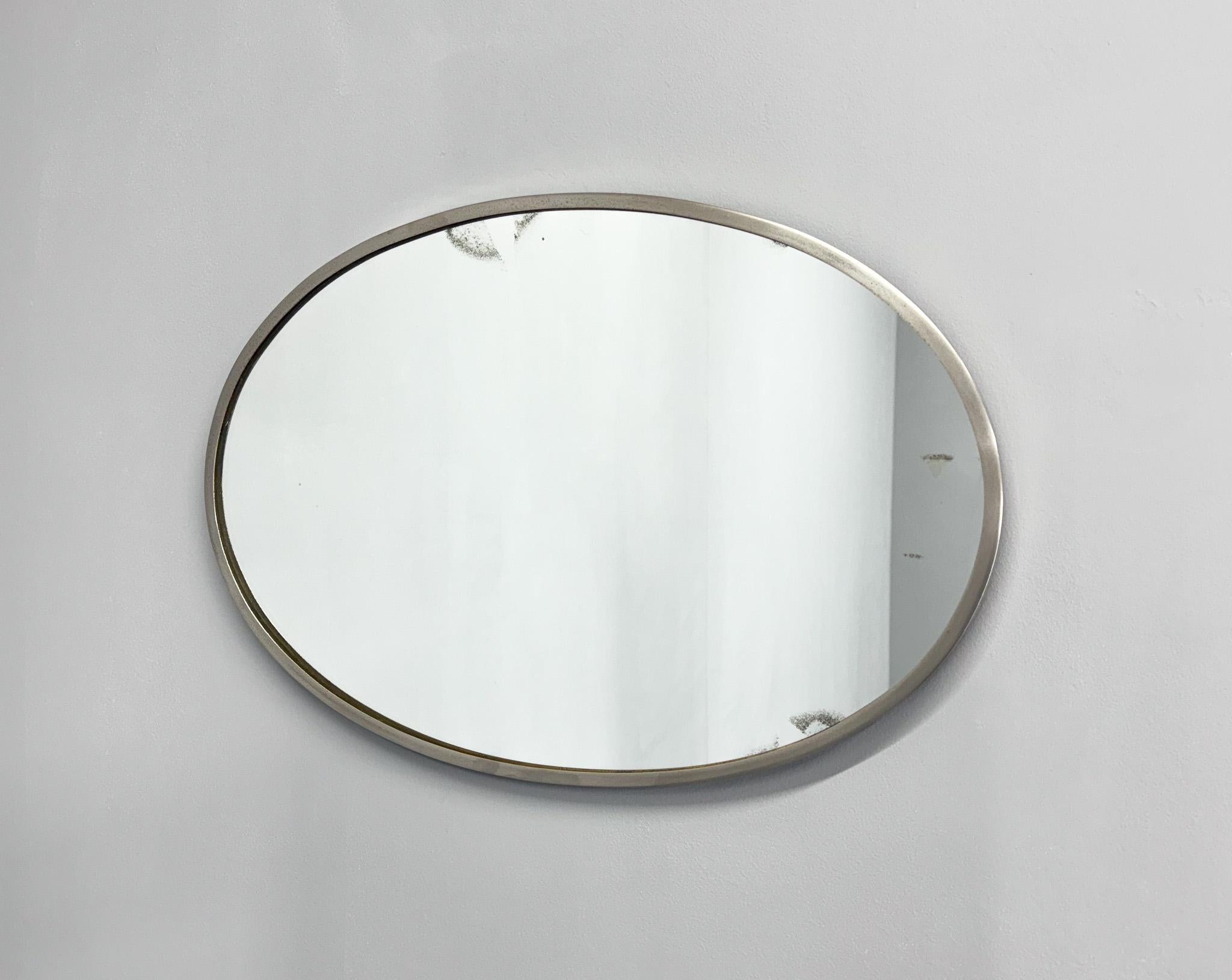 Miroir mural ovale en métal chromé. Le dos du miroir est recouvert de velours d'origine. Le miroir lui-même montre des signes du temps, ce qui lui donne une belle patine.