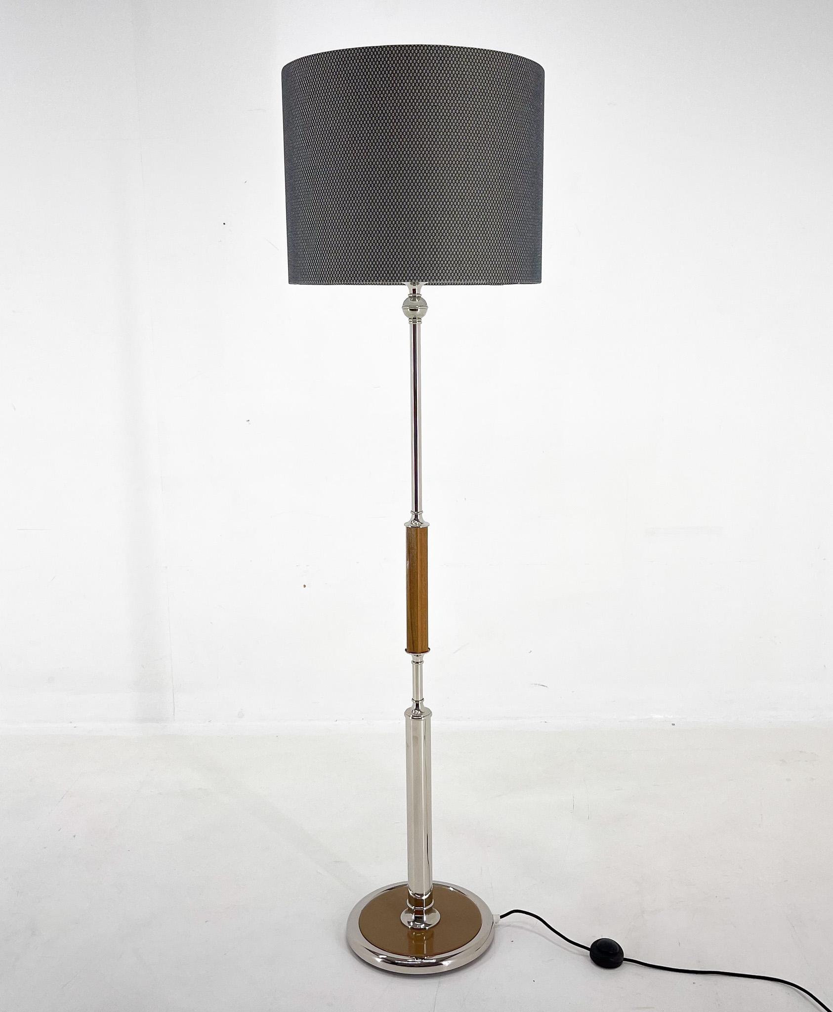 Mid-century floor lamp from Former Czechoslovakia. Made of chrome and wood with step-on switch. 
The lamp was restored, has new wiring and new handmade lamp shade. 
Bulb: 1 x E25-E27. US plug adapter included.