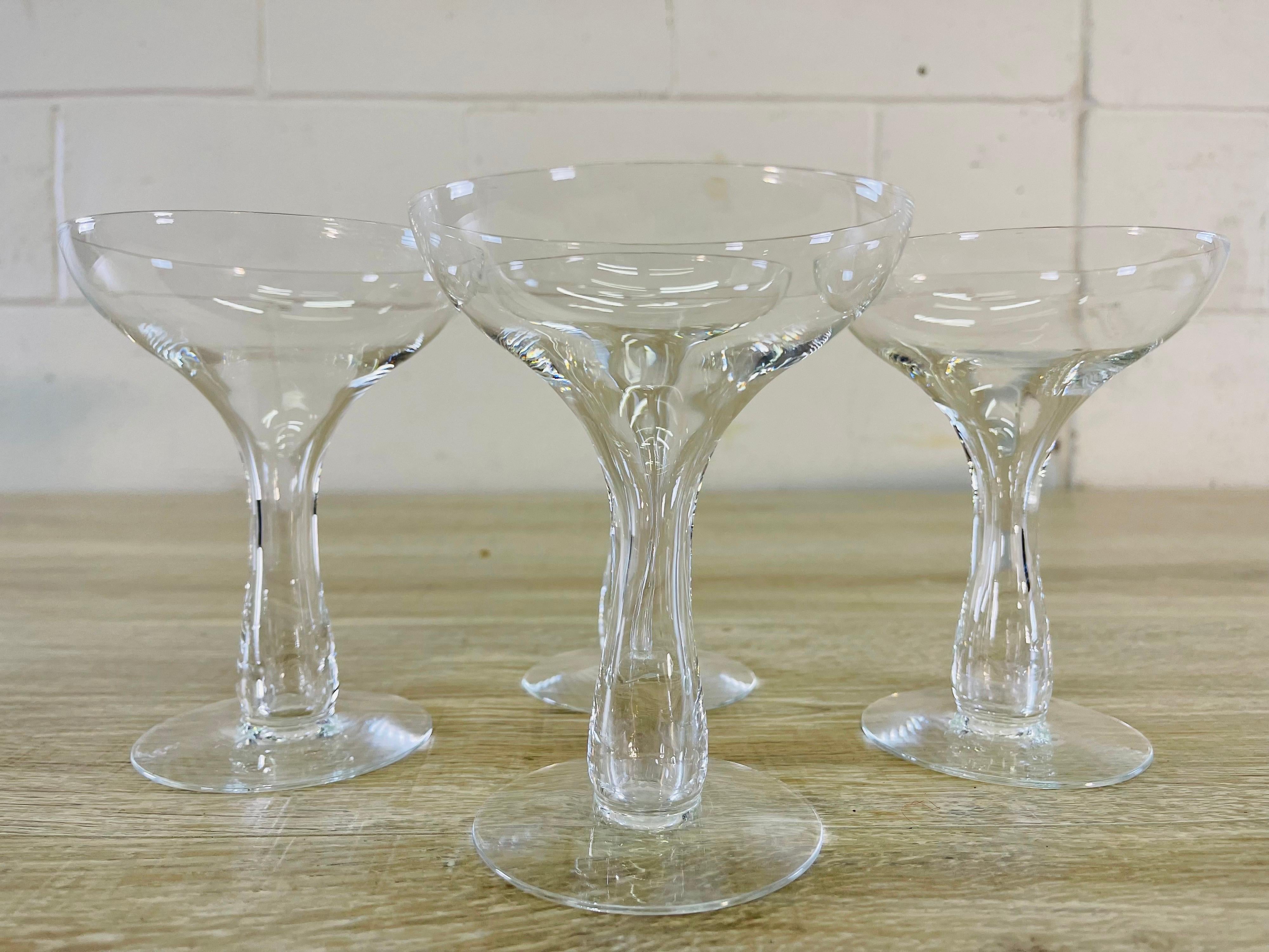 Vintage 1950s set of four clear glass hollow stem coupe stems. No marks.