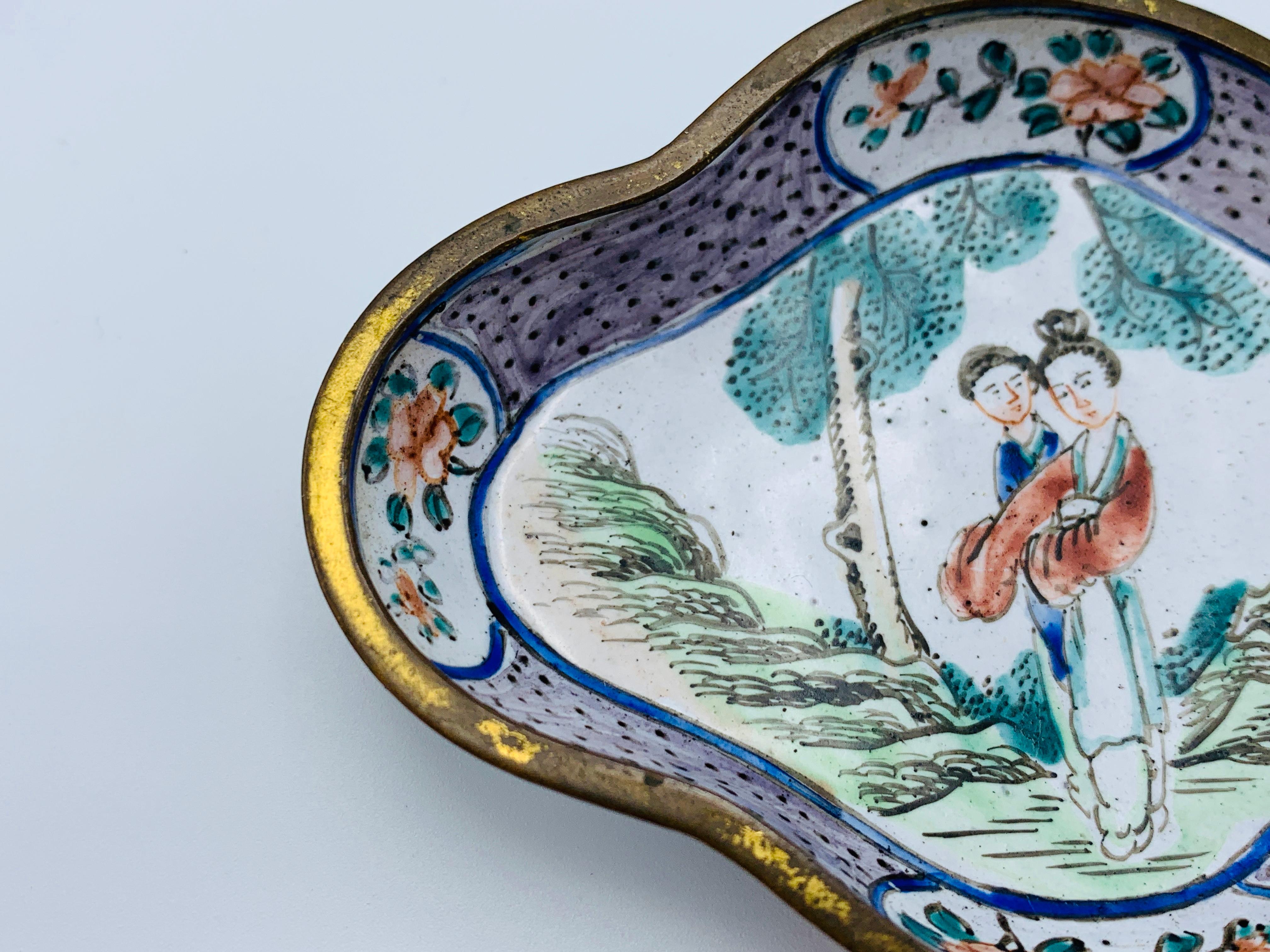 Listed is a stunning, 1950s cloisonné ring dish with a scalloped shape. The piece has a beautiful, ornate figural scene with a floral motif border. Marked on backside, see last photo.