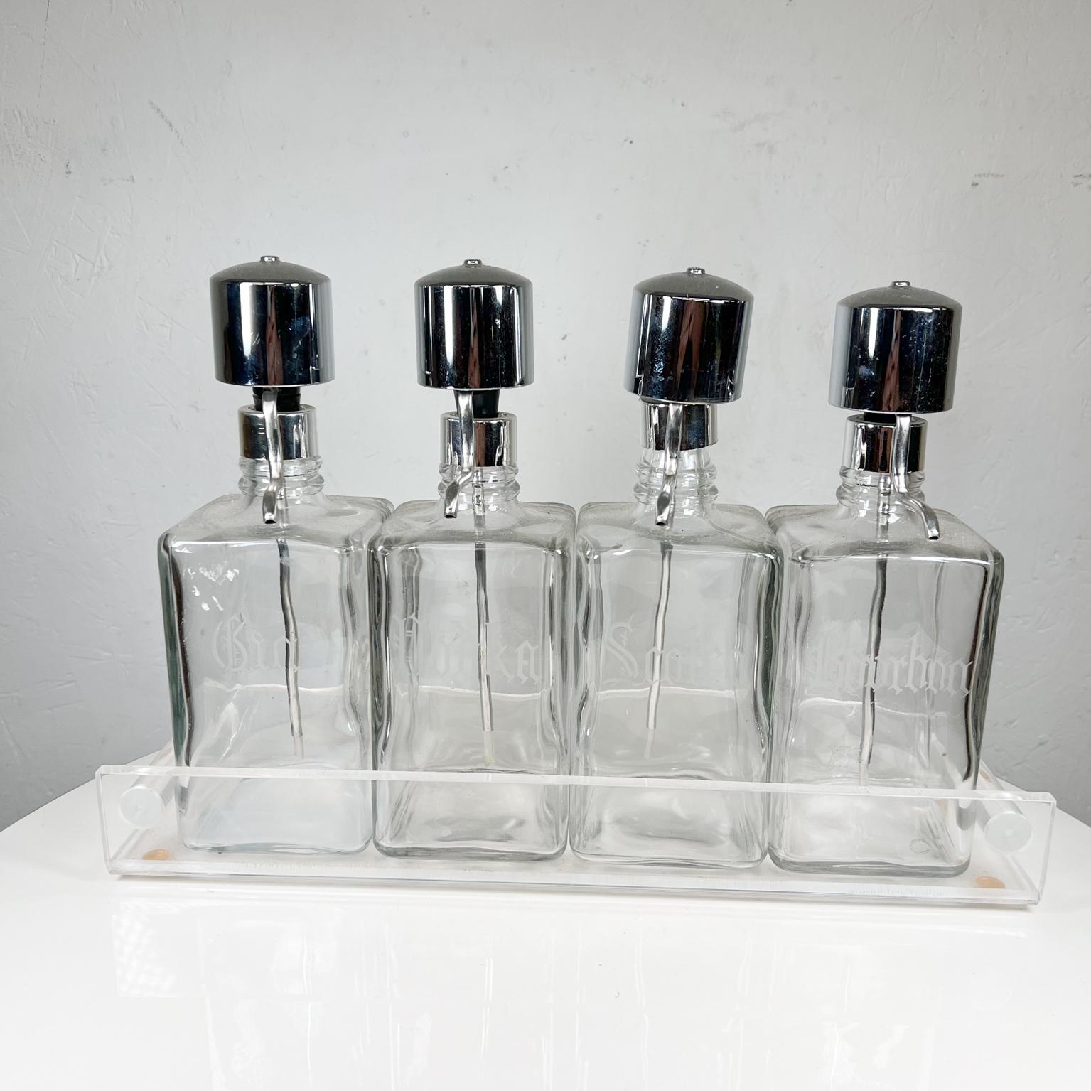 Set of Four Dispenser Liquor Bottles Scotch Bourbon Gin Vodka Etching
16.75 w x 4.5 d x 11.25 tall
Each bottle 3.63 x 3.63 x 10.5 tall
Set of 4 liquor bottles with chrome push dispenser in a Lucite Caddy
No information on maker
Preowned vintage