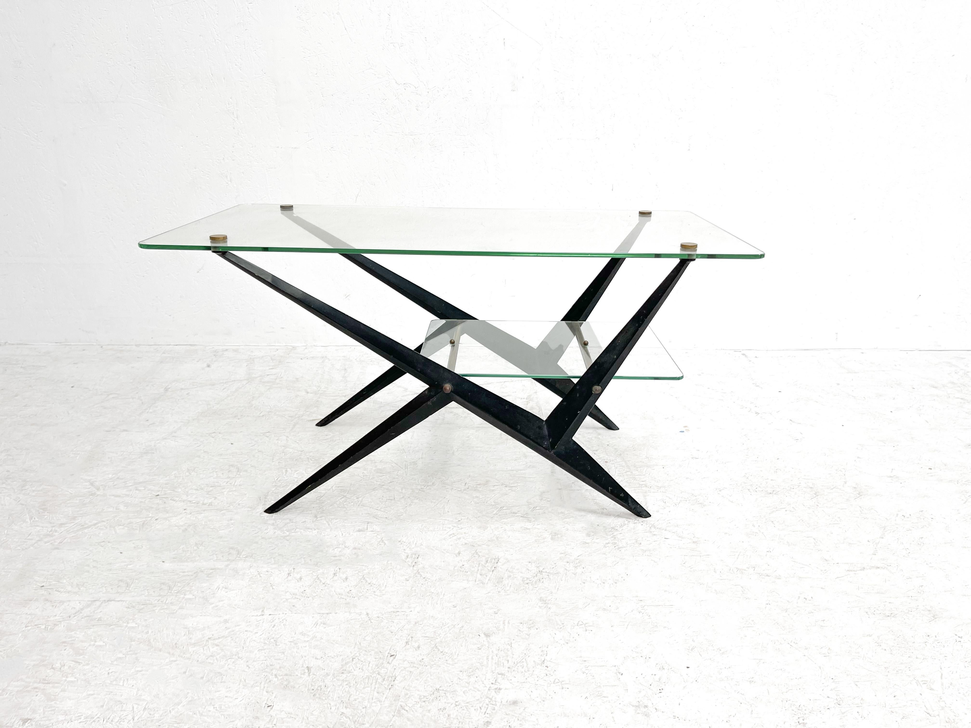Coffee table by Angelo Ostuni
High quality coffee table made by Angelo Ostuni. Angelo Ostuni designed this coffee table in the early 50's. The table features a black lacquered frame with glass shelves and brass details. The table is a good example