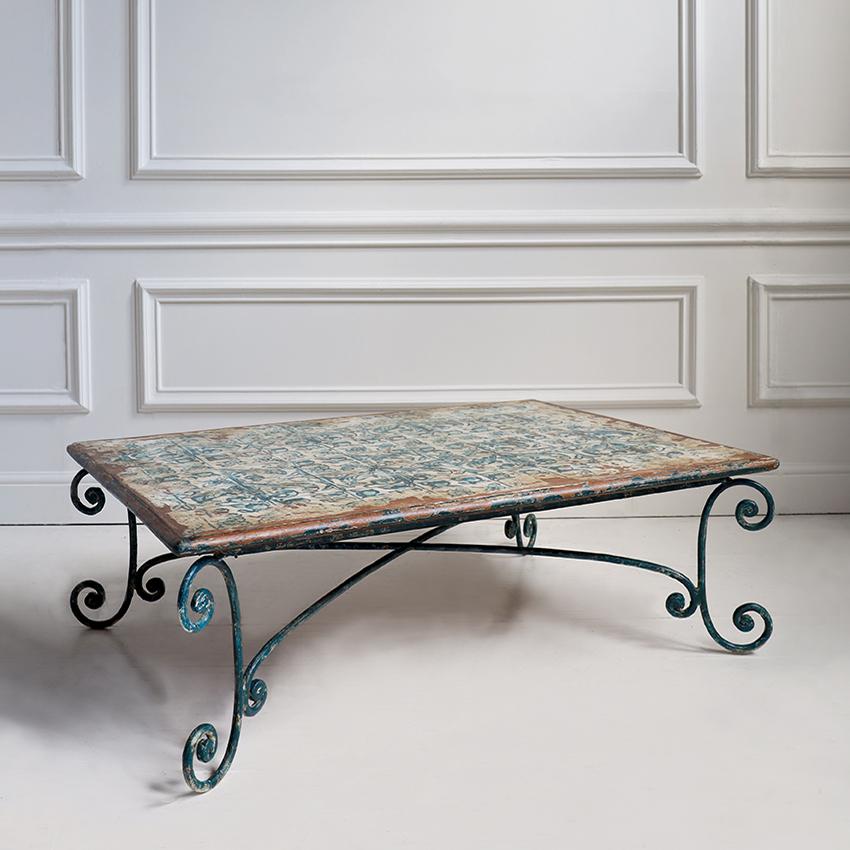 Une charmante table basse du milieu du siècle dernier qui charme par son élégance décontractée et sophistiquée le style Riviera italienne ou méditerranéen des années 1950. Le plateau rectangulaire en bois est orné d'un superbe motif peint en
