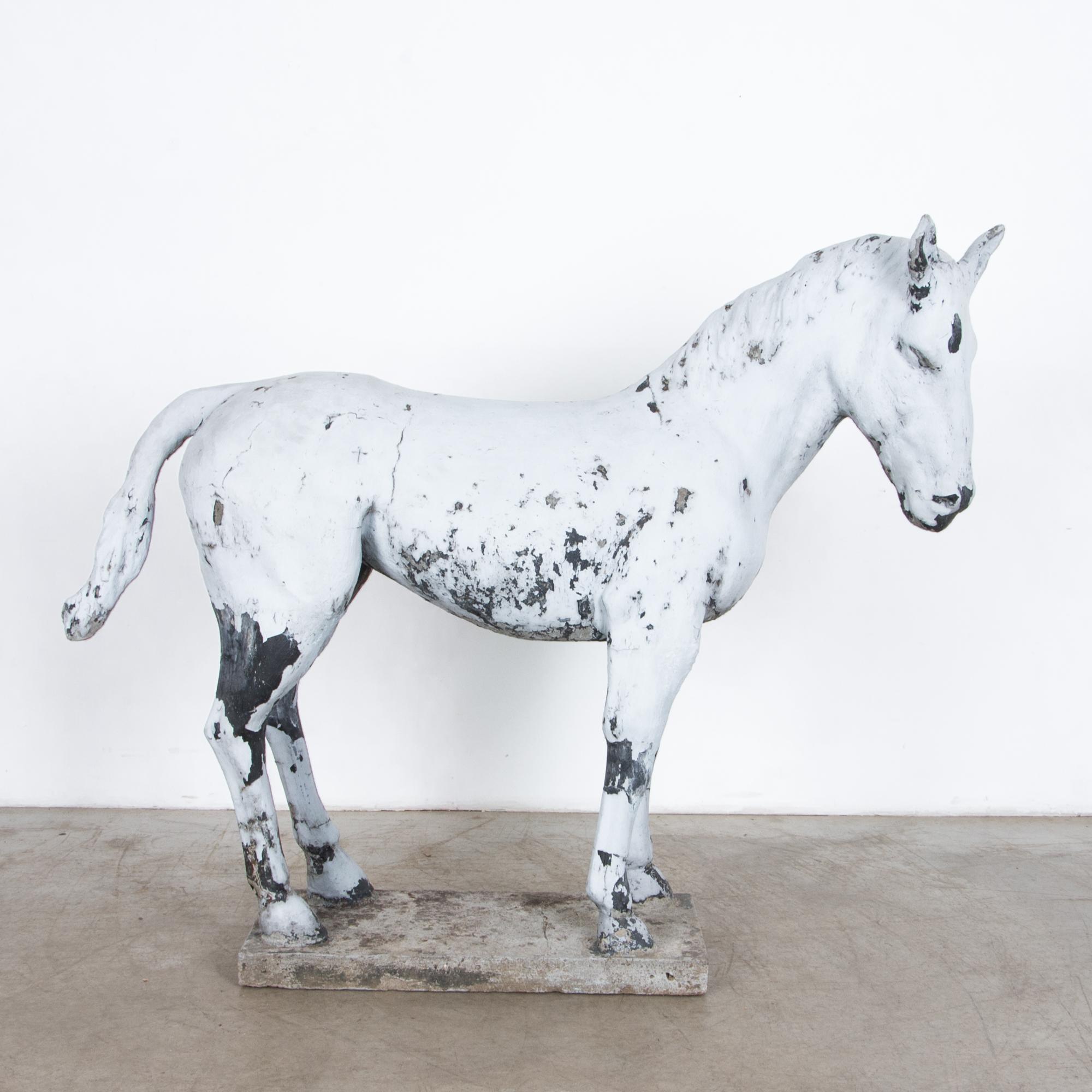 From 1950s France, a large painted cast-concrete donkey sculpture. At five feet long, this sculpture depicts a humble working animal. A textural decoration or conversation piece with original 1950s patina.