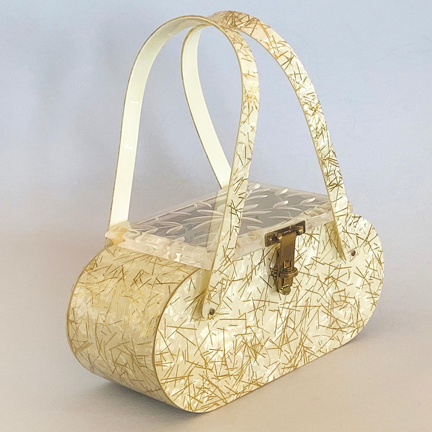 Art Deco Lucite Handbag, in Yellow Pearl with Gilt Strips imbedded throughout. Top lid is in Deep Carved, Clear Lucite in Daisy and Leaves pattern; original brass clasp with turn locking still intact and working perfectly. The interior is clean and