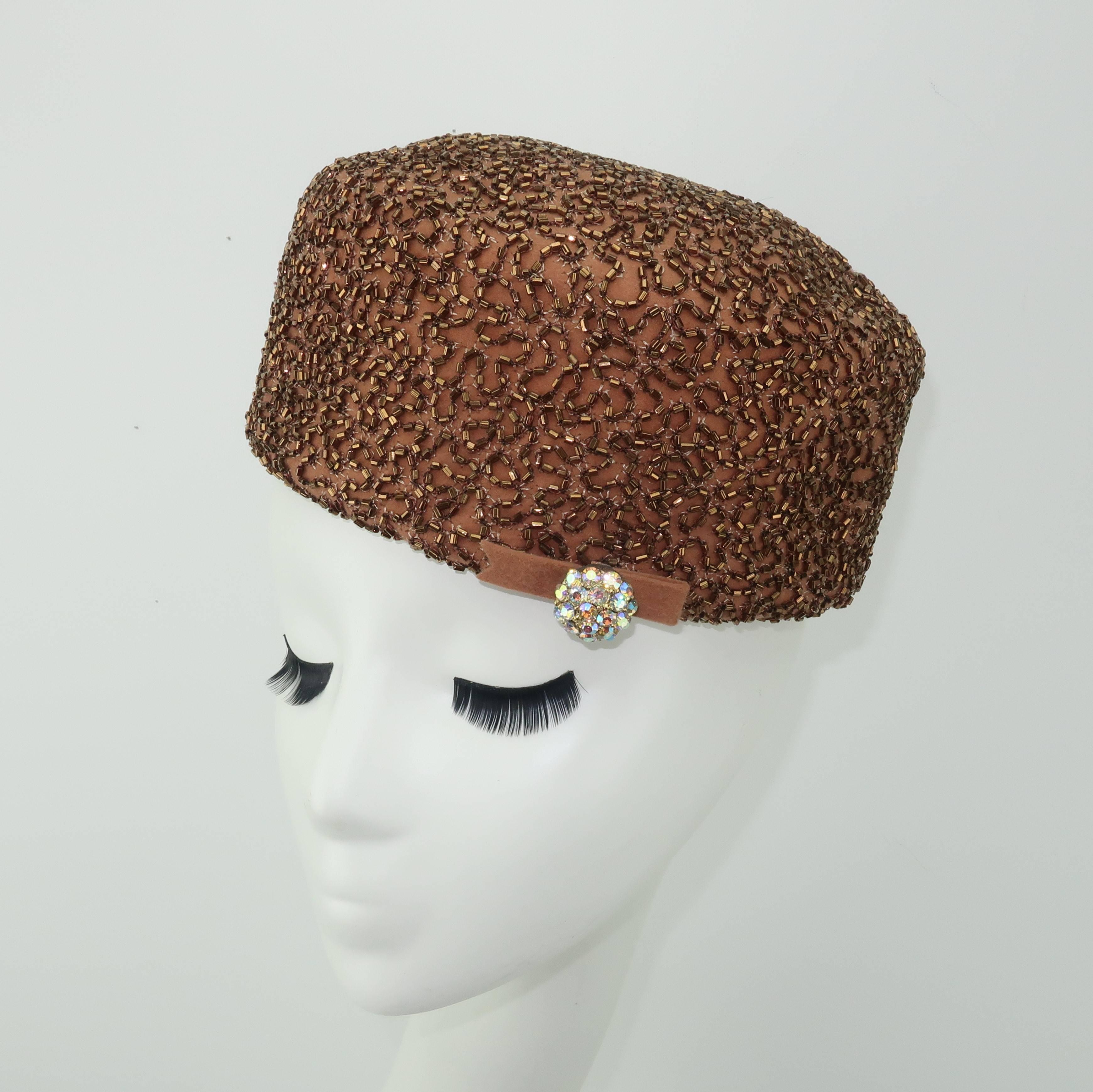 A glamorous topper from the California based millinery firm, Leslie James, is a fun way to add a vintage accessory to a modern day ensemble.  This beautifully made brown felt wool pillbox hat is embellished with copper bugle beads in a vermiculated