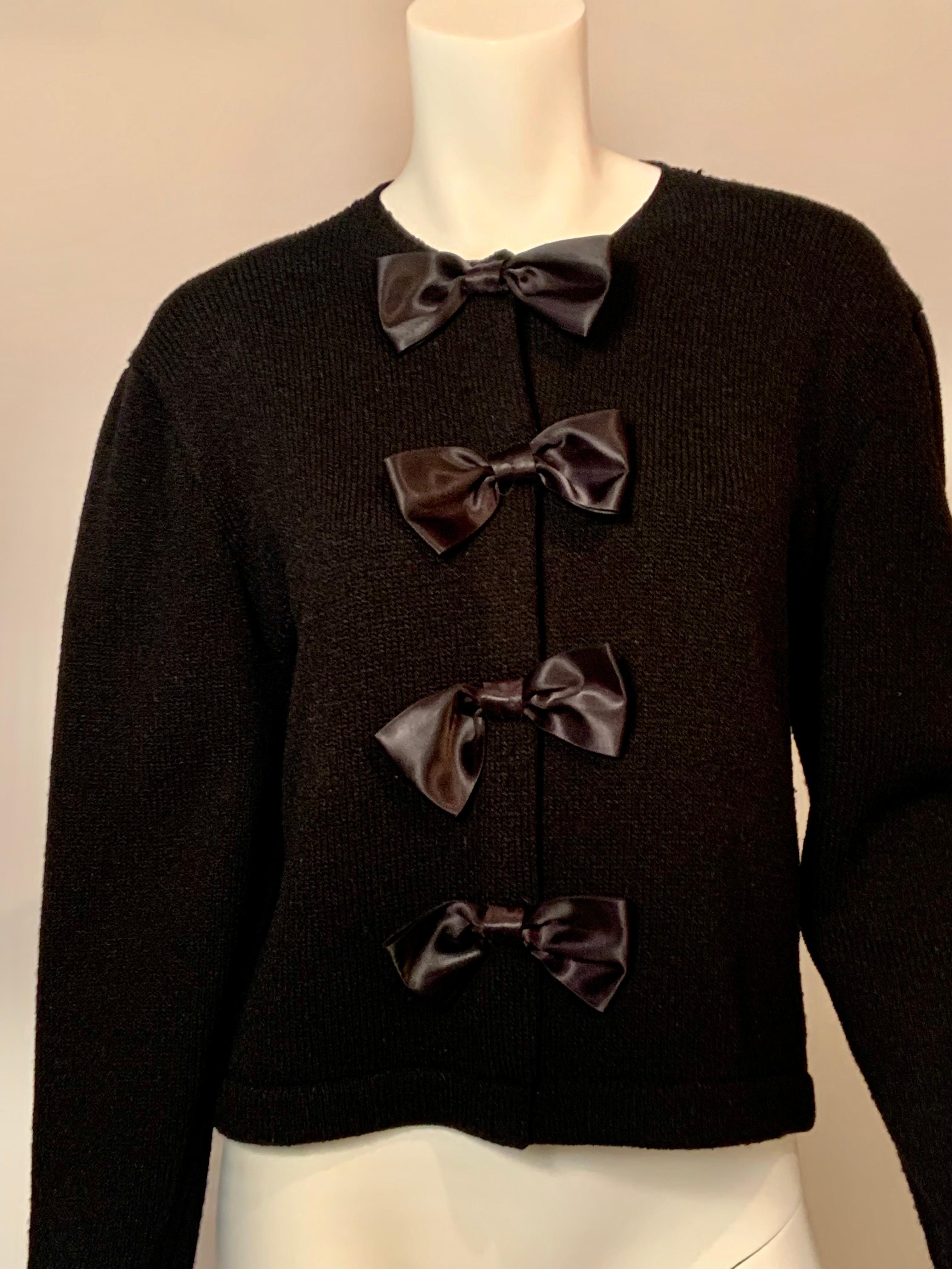 This 1950’s sweater by Corinne O’Hare is elevated by the black satin bows placed over the
snaps at the center front. It is in excellent condition and marked a vintage size 18.
Measurements; Shoulders 18” Bust 42” Waist 38”. Sleeves 23”. Length. 26”