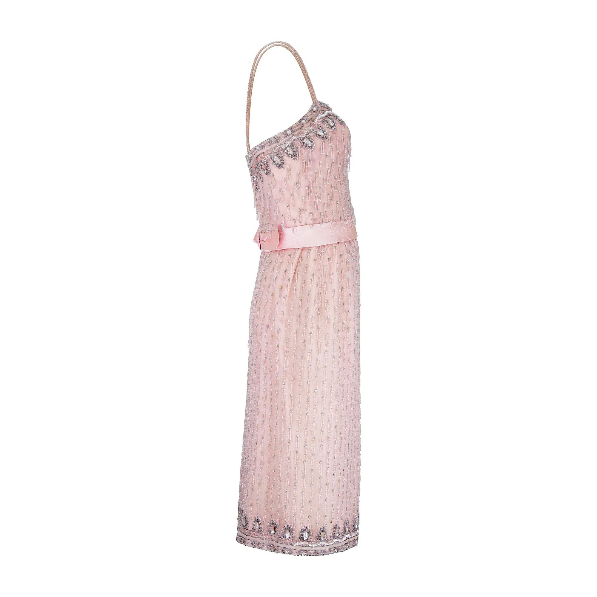 Couture made in the 1950s, this truly stunning pale pink gown has retained all of the delicate intricacy of when it was first designed.  With elaborate bead work, it is cut to a fitted, body skimming silhouette with spaghetti straps. The dress is