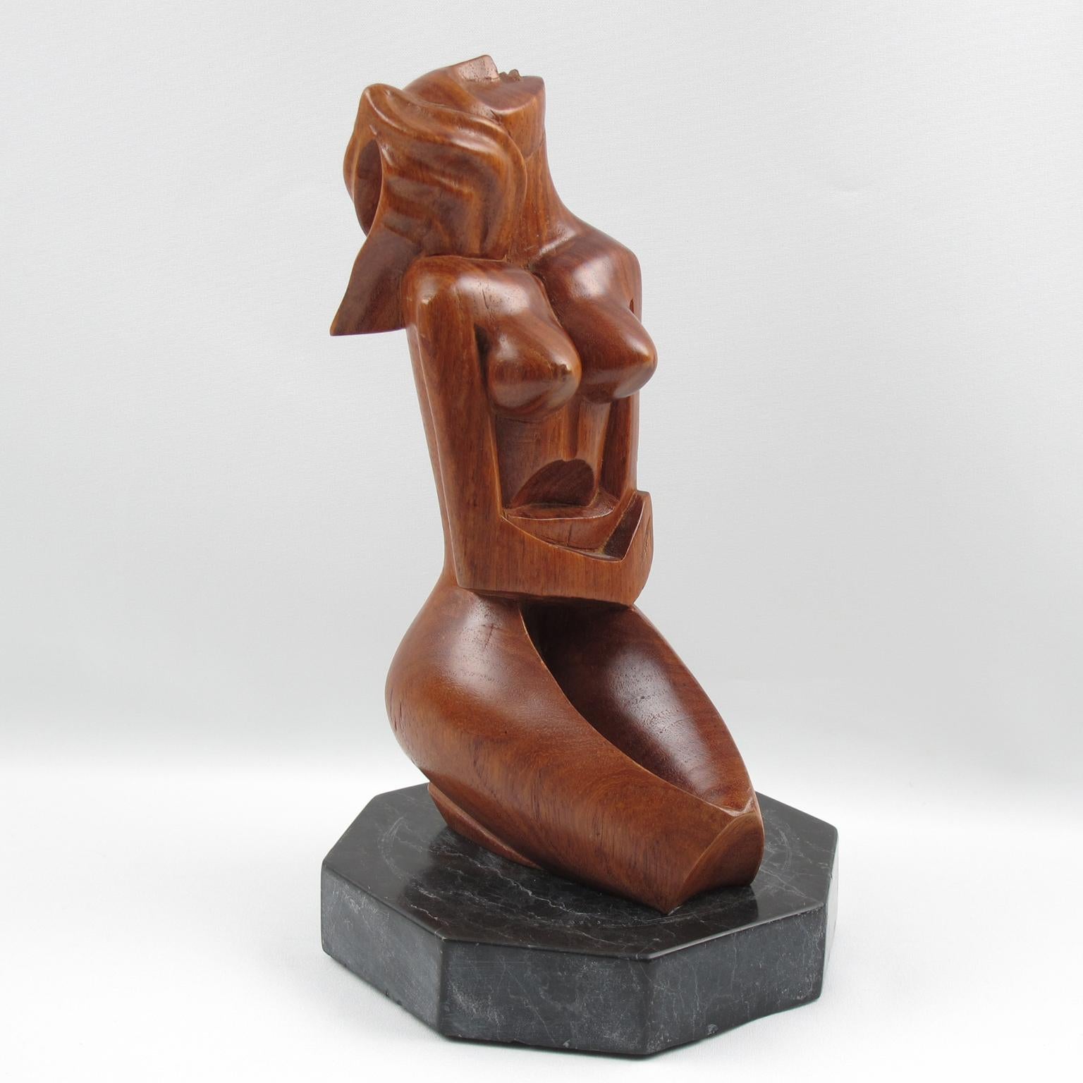 Stunning modernist 1950s wood sculpture, featuring a crouched woman in cubist style carving. Very nice carved movement of the body and the unusual position of the head. Tropical wood all hand-carved, seating on a large faceted black marble base. No