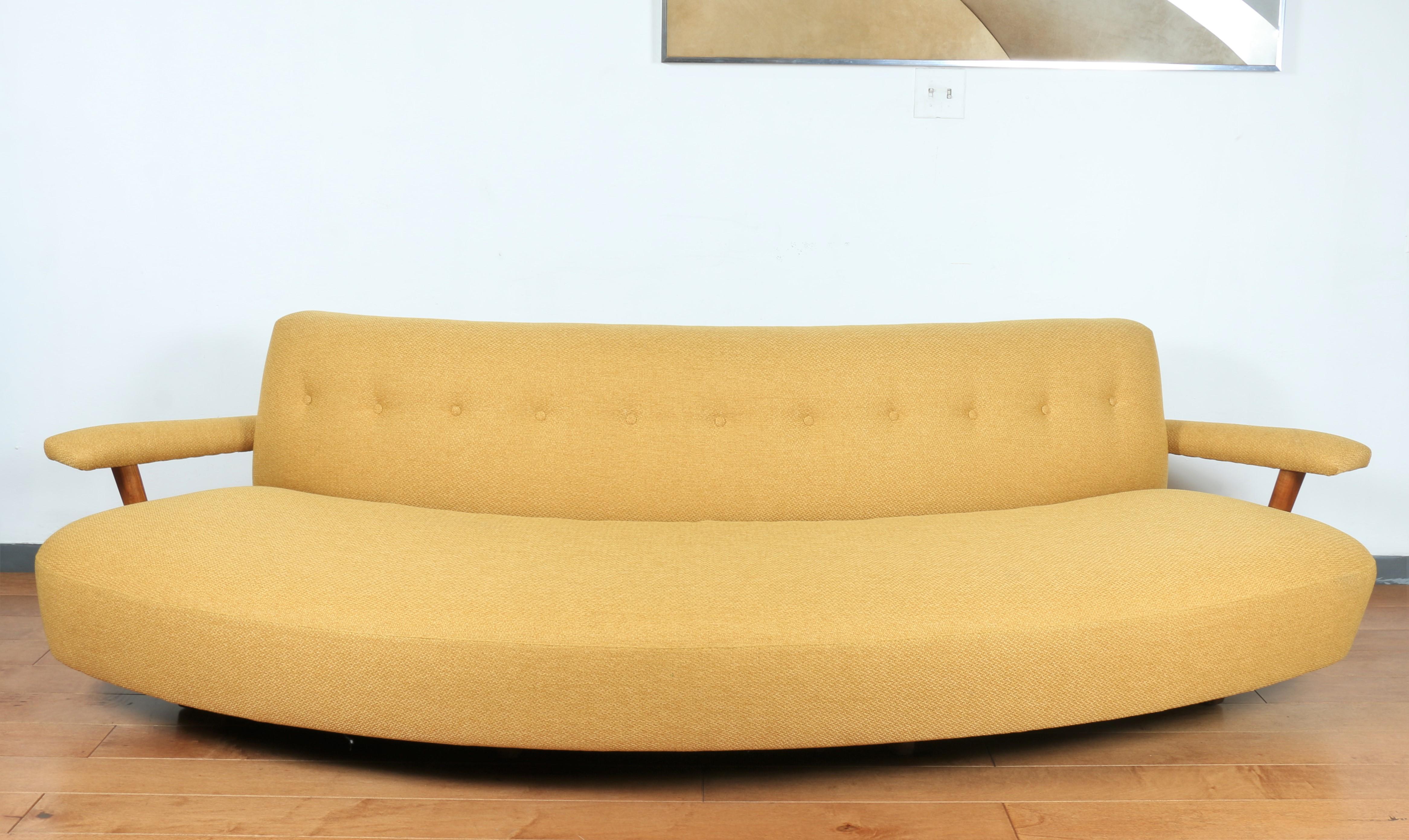 Mid Century curved yellow sofa with oak wood arm rest. In very good condition, no stains or marks. New upholstery was made. American made sofa from the 1950's.
