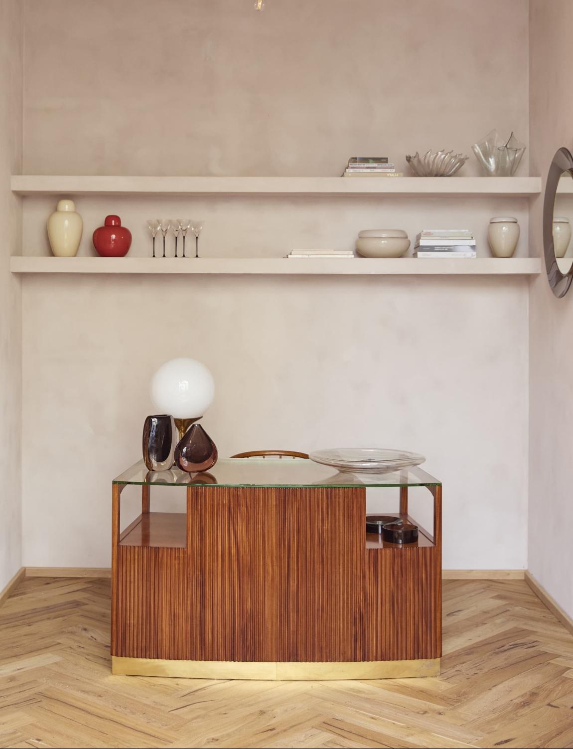 A superb Italian mid-century rosewood desk, attributed to Paolo Buffa (1903–1970), Milan. The piece is distinguished by its beautifully fluted Art Deco rosewood façade and thick raised glass top. The desk has three drawers, one large central desk