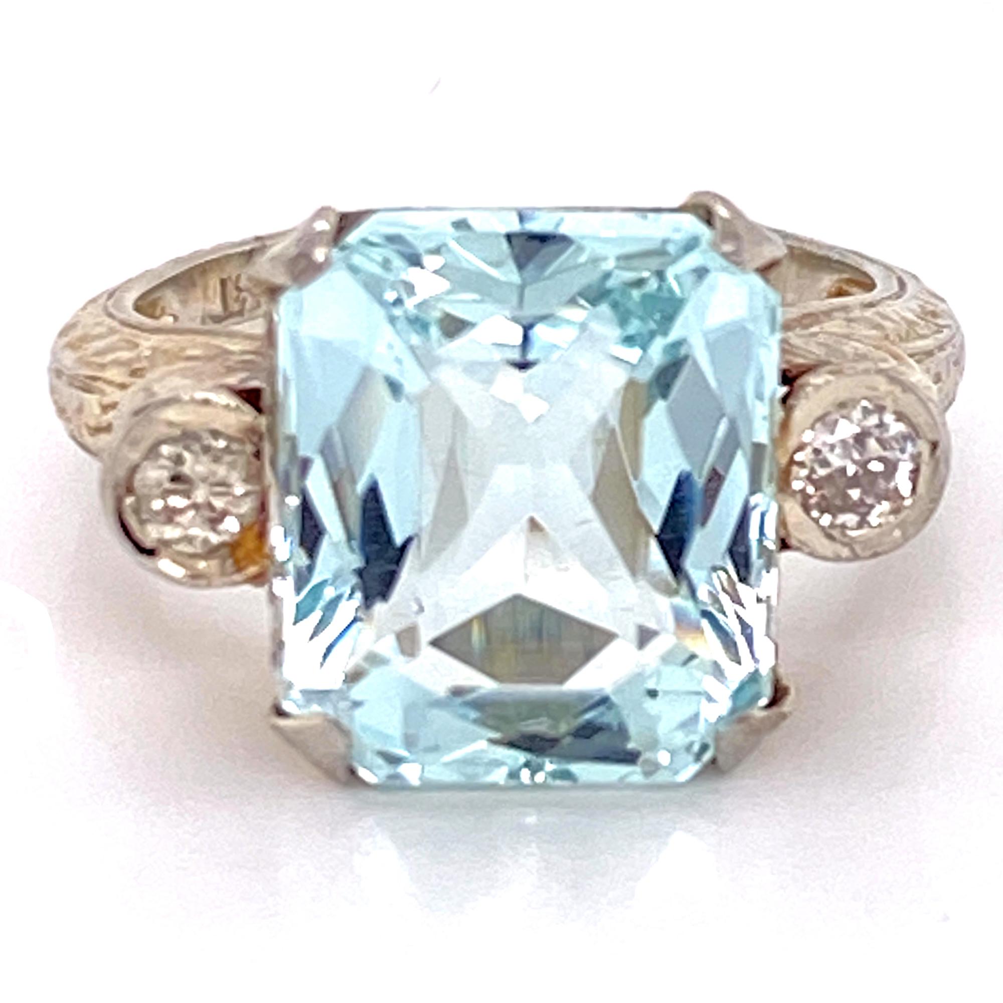 1950's aquamarine and diamond cocktail ring hand made in 18 karat white gold. The ring features a 5.85 carat cushion cut aquamarine flanked by two round brilliant cut diamonds weighing .18 carat total weight. 

The aquamarine measures 10 x 12.5mm,