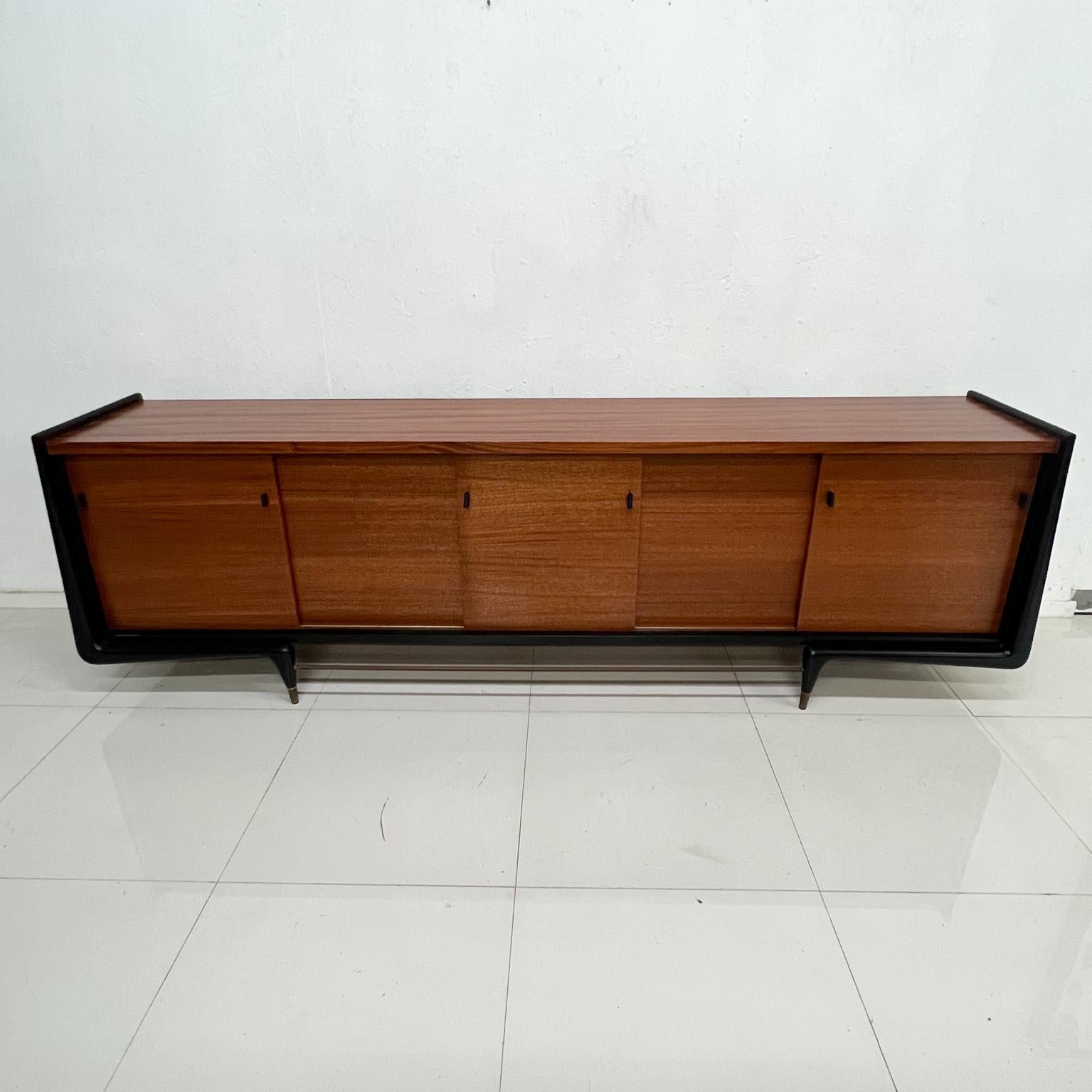 Dramatic Mexican Modernism 1950s custom credenza sideboard showpiece
Mahogany ebonized wood leather and brass accents.
Unmarked, attributed style of Eugenio Escudero Mexico City.
Approximately 100.5 wide x 19.5 deep x 30.75 tall 
Top is 30 -