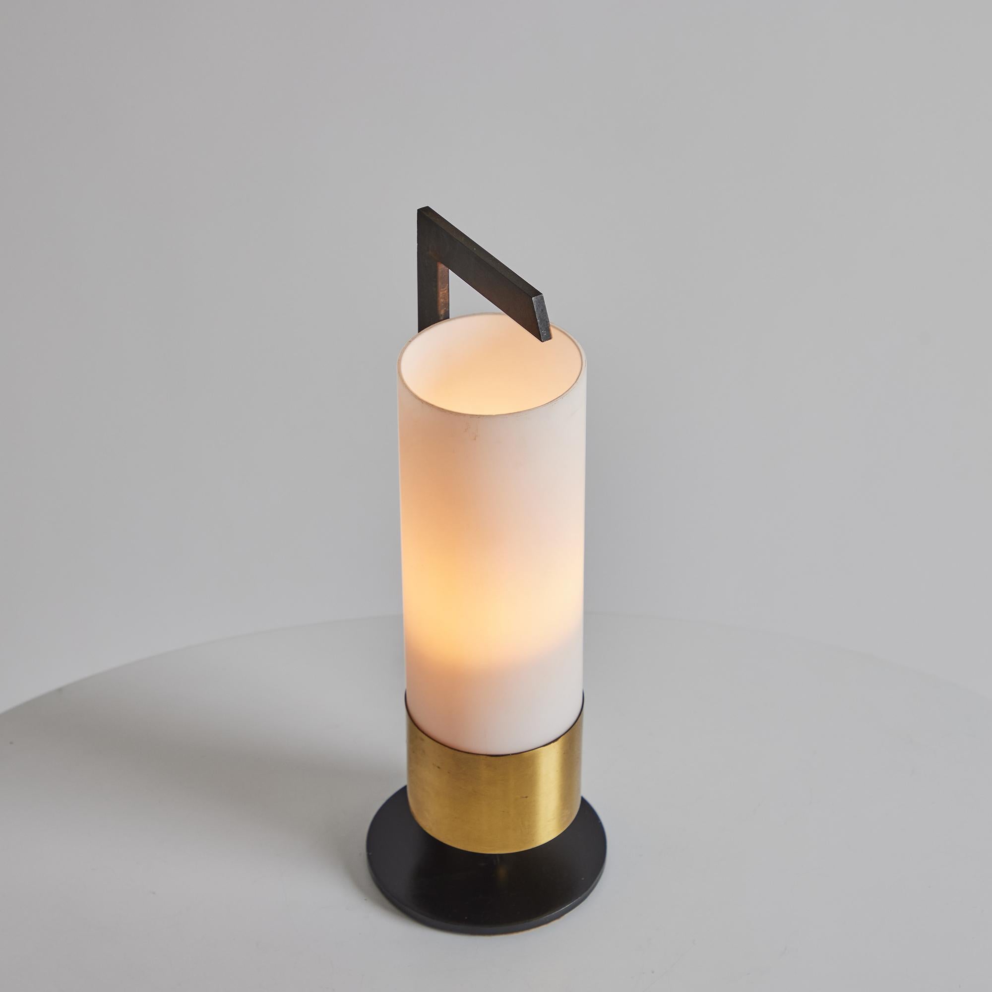 1950s Cylindrical Brass and Opaline Glass Table Lamp for Arlus.

Executed in opaline glass and patinated brass, this refined table lamp is attributed to French lighting manufacturer Arlus. Minimalist yet highly functional, its warm diffused light is