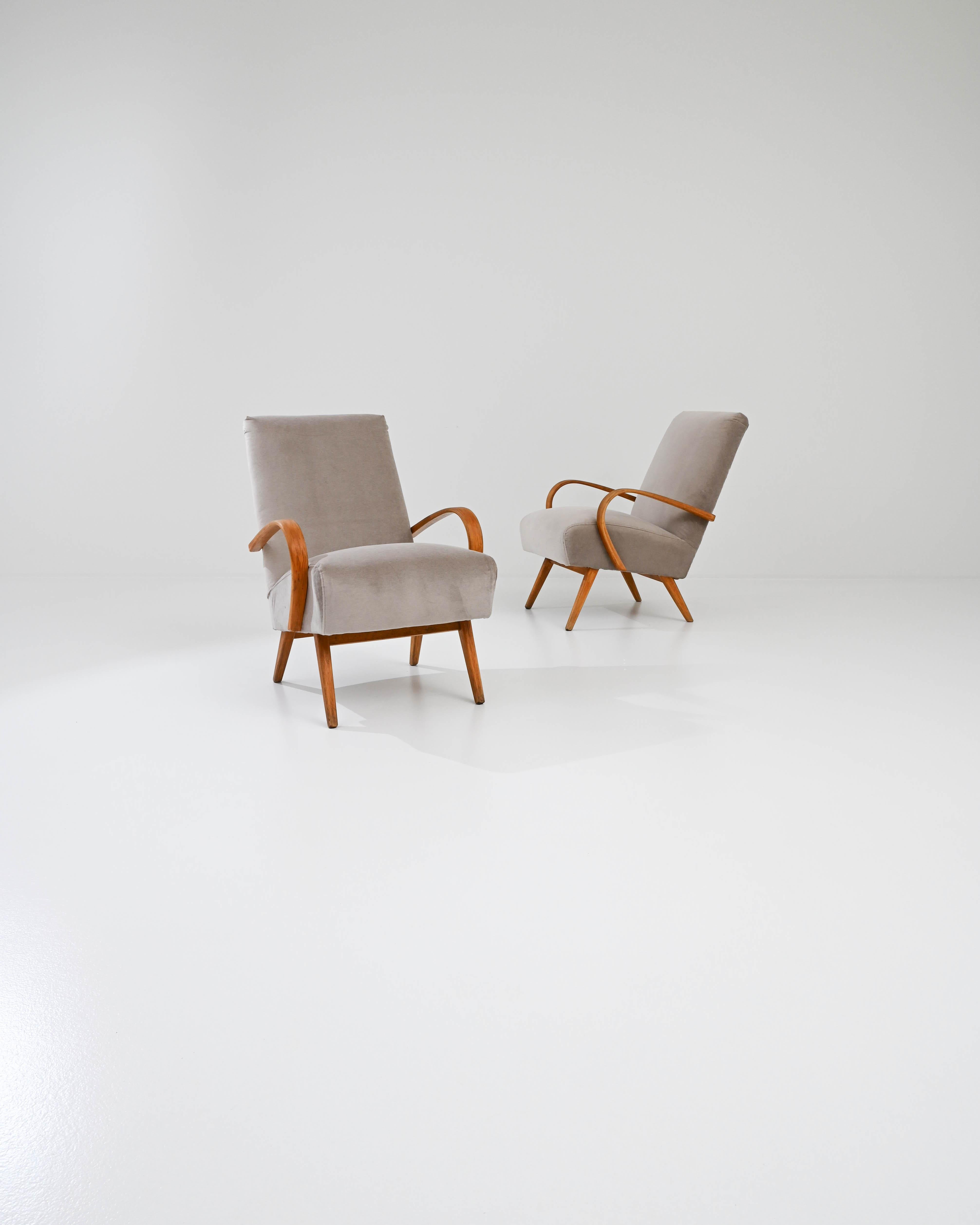 Fabriquée dans l'ancienne Tchécoslovaquie, cette paire de fauteuils en bois courbé datant d'environ 1950 a été retapissée avec un tissu neutre actualisé. Le revêtement velouté a été choisi pour compléter l'élégance vintage du cadre en bois dur noir.