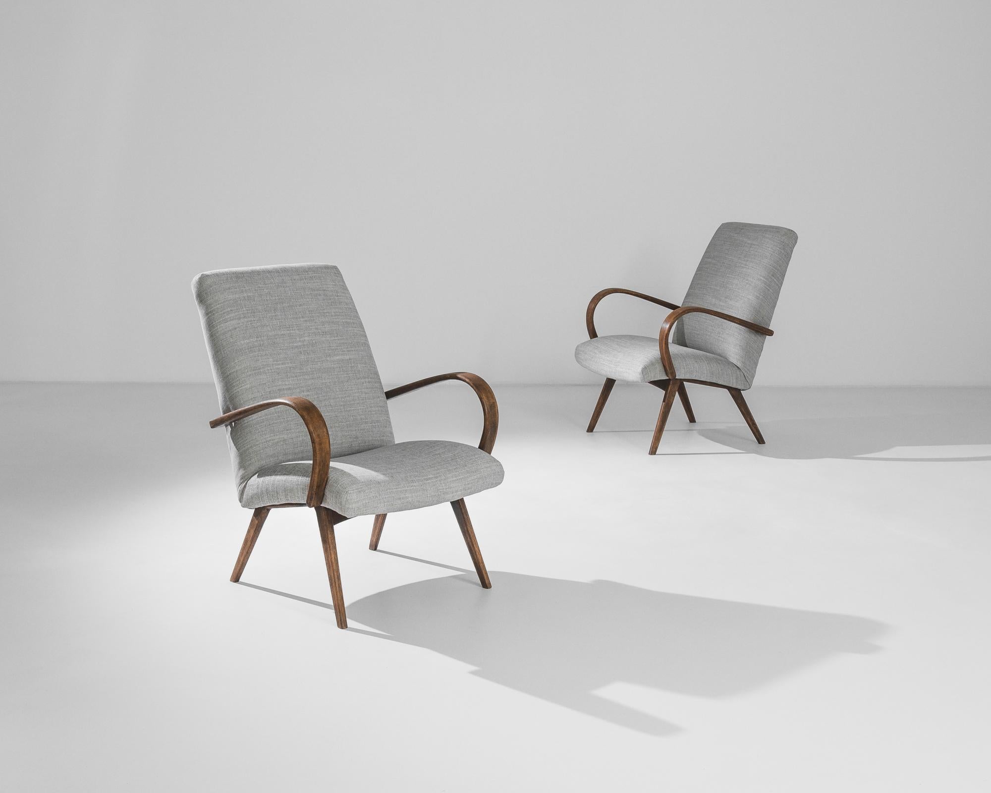 Fabriquée dans l'ancienne Tchécoslovaquie, cette paire de fauteuils en bois courbé datant des années 1950 a été retapissée avec un tissu gris moderne. Le mélange coton-lin a été choisi pour compléter l'élégance vintage de la structure en bois dur