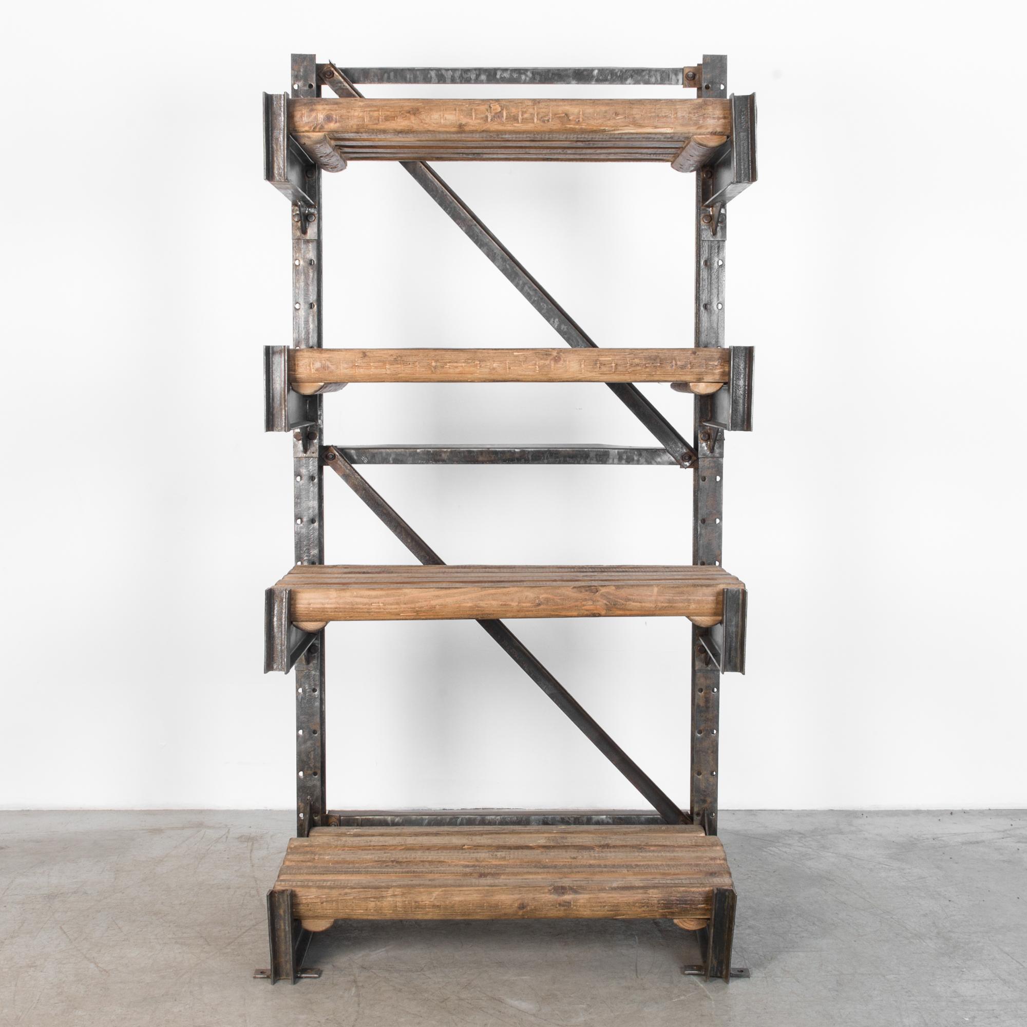 This is a wood and steel shelving unit from Czech Republic, circa 1950. Gorgeous worn patina, these thick wooden shelves are supported by a heavy duty modular steel shelving system. Metal braces give a physical and visual stability, interrupted by a