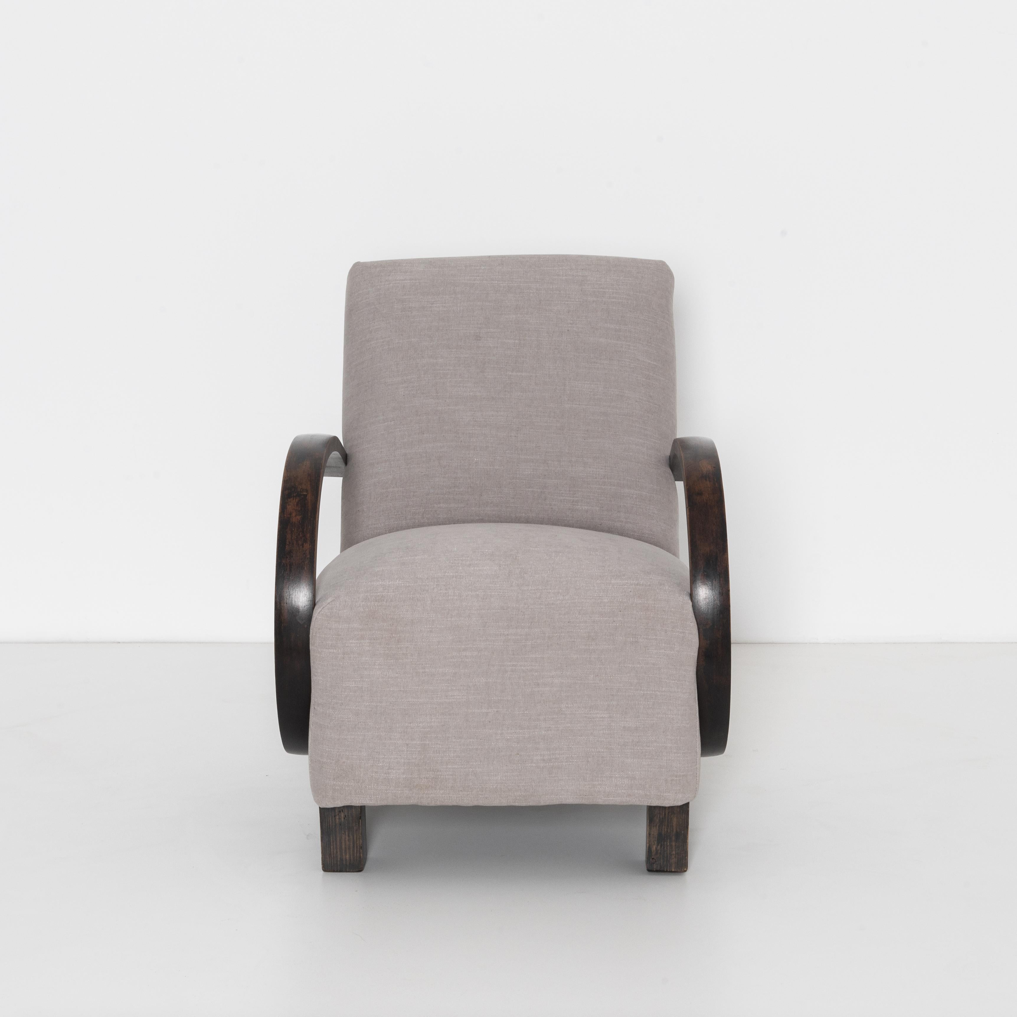 Mid-Century Modern upholstered armchair from Czech Republic, circa 1960. A timeless approach that still looks contemporary and fresh. In the style of Jindřich Halabala with bent beech armrests and geometric legs, re-upholstered with a light grey