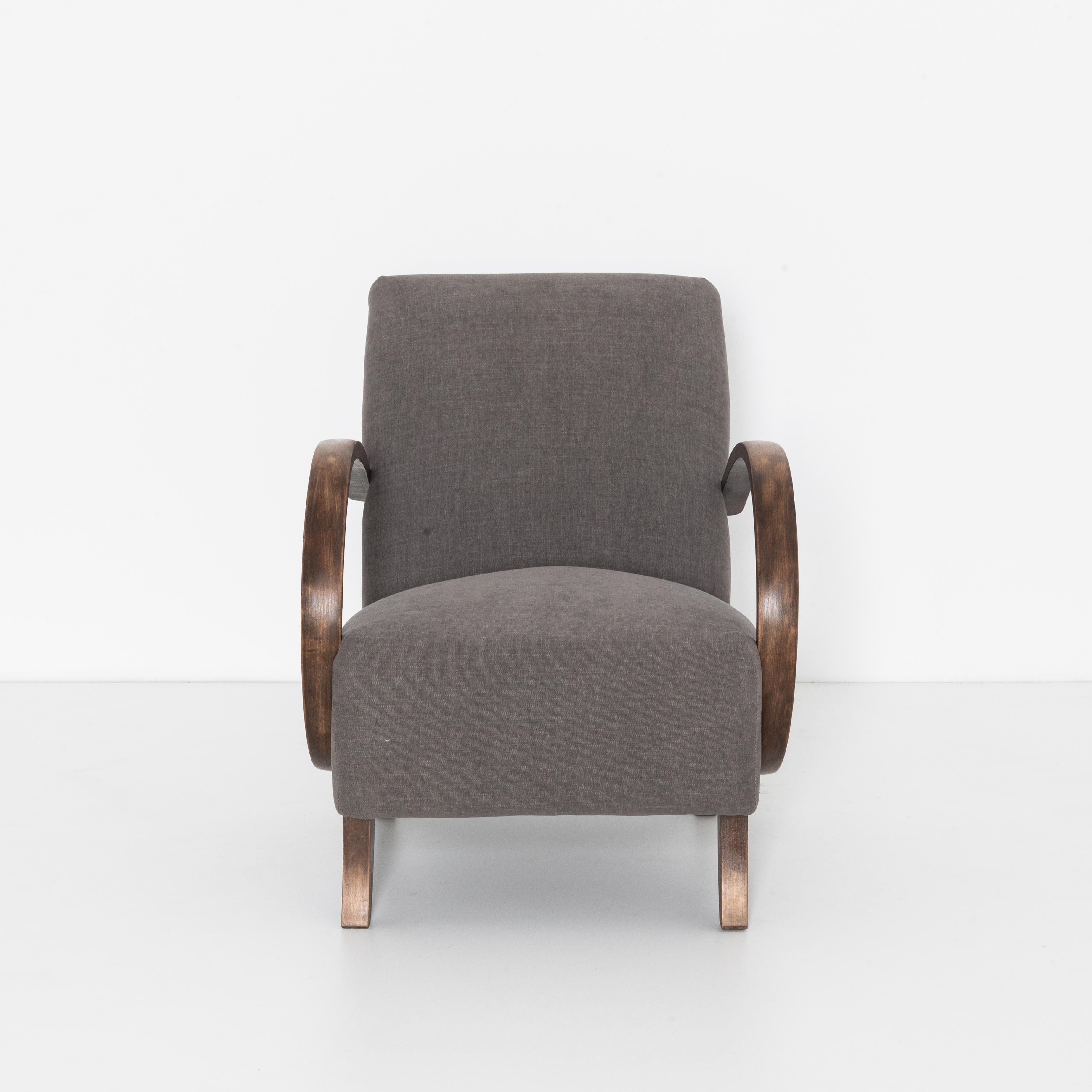 Mid-Century Modern upholstered armchair from Czech Republic, circa 1960. A timeless approach that still looks contemporary and fresh. In the style of Jindrich Halabala with bent beech armrests and geometric legs, re-upholstered with a grey