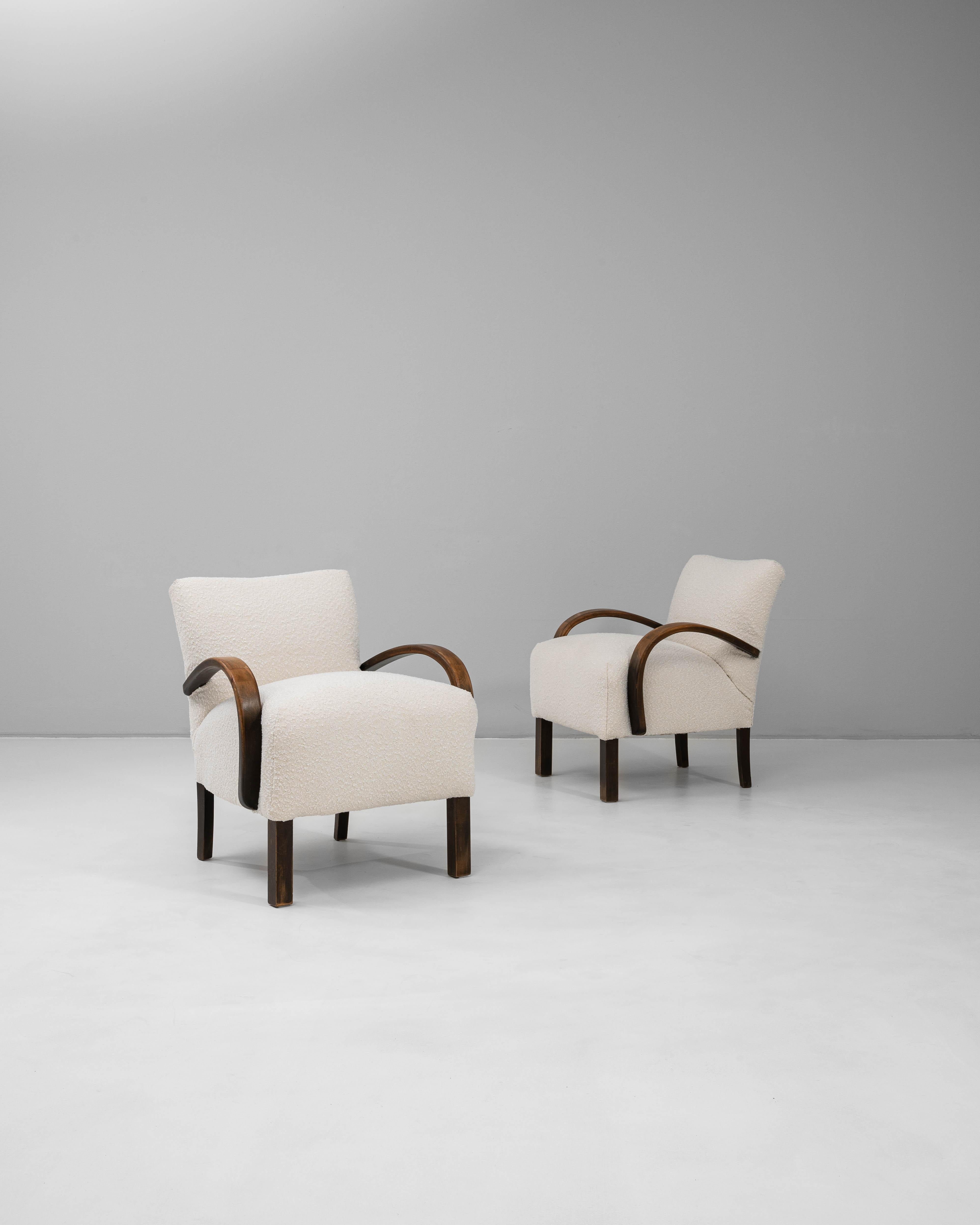 This 1950s Czech pair of upholstered cocktail armchairs, model H-237 by Jindřich Halabala, exemplifies the designer’s elegant fusion of modernist form and comfort. Each chair features Halabala’s signature curved beechwood arms, gracefully sweeping