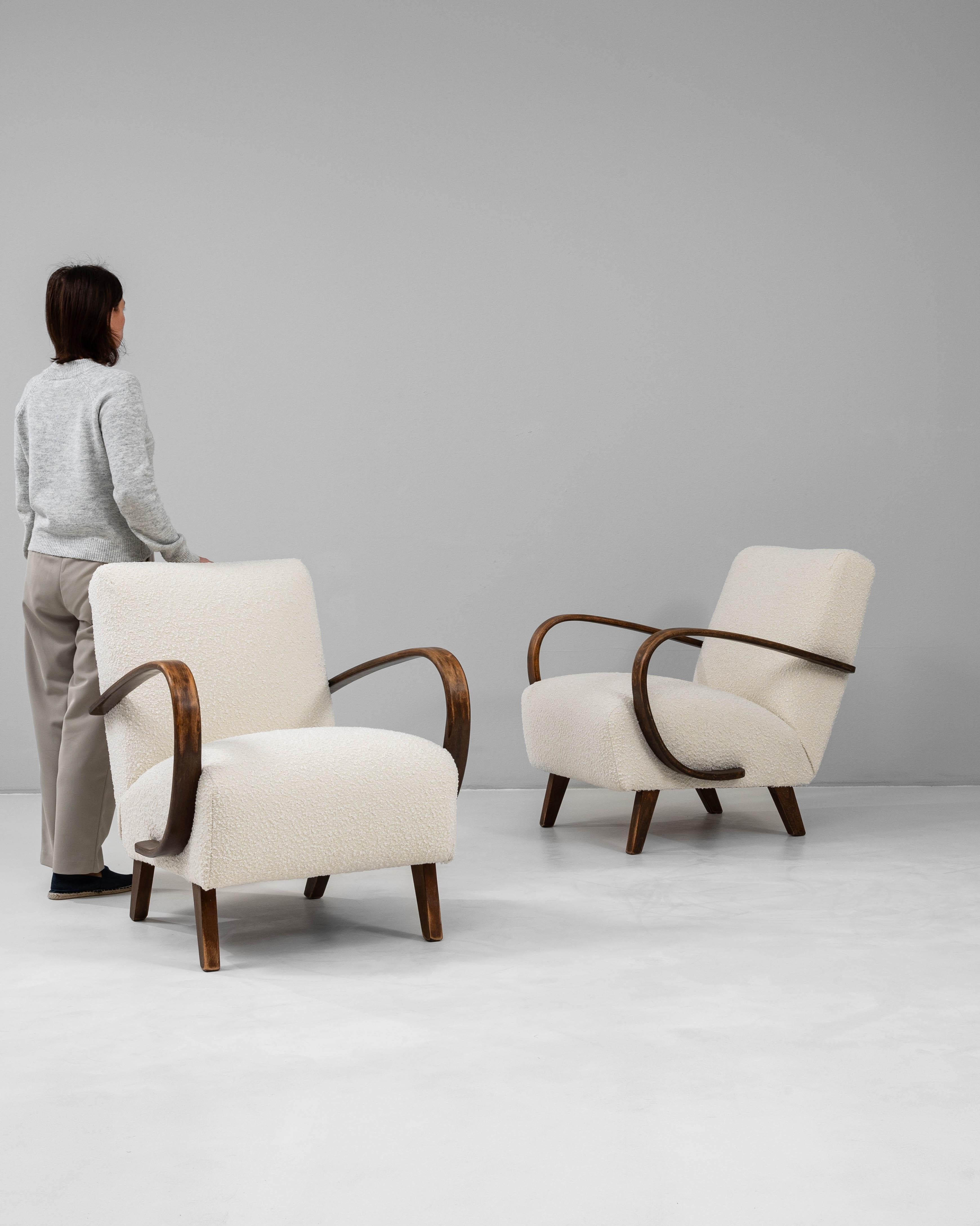 Cette paire de fauteuils en bois tchèque des années 1950 de J. Halabala illustre le design moderne du milieu du siècle avec son mélange caractéristique de simplicité et d'élégance. Chaque fauteuil est doté des emblématiques accoudoirs en bois de