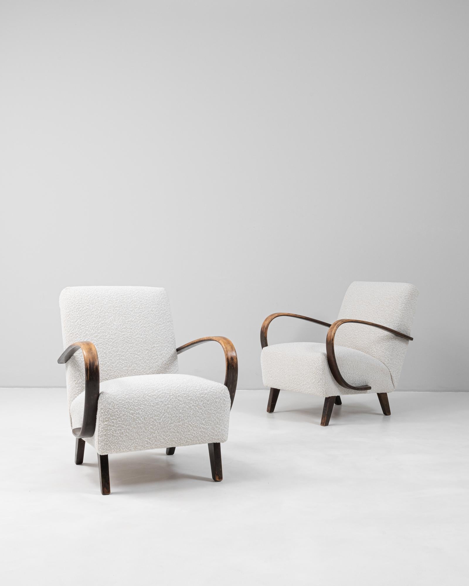 Cette paire de fauteuils en bois tchèque des années 1950 de J. Halabala illustre le design moderne du milieu du siècle avec son mélange caractéristique de simplicité et d'élégance. Chaque fauteuil est doté des emblématiques accoudoirs en bois de