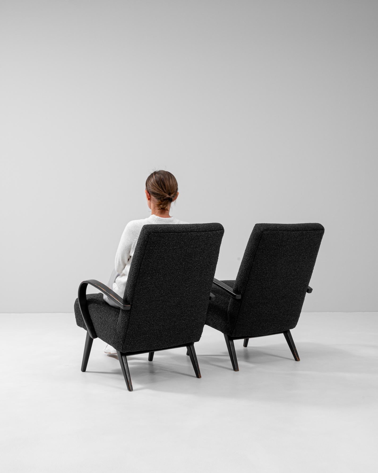 This pair of 1950s upholstered armchairs by Jindřich Halabala exemplifies the designer’s iconic fusion of comfort, modernism, and expressive form. Featuring his signature bentwood arms, the frames are finished in a dark stain with visible wear that