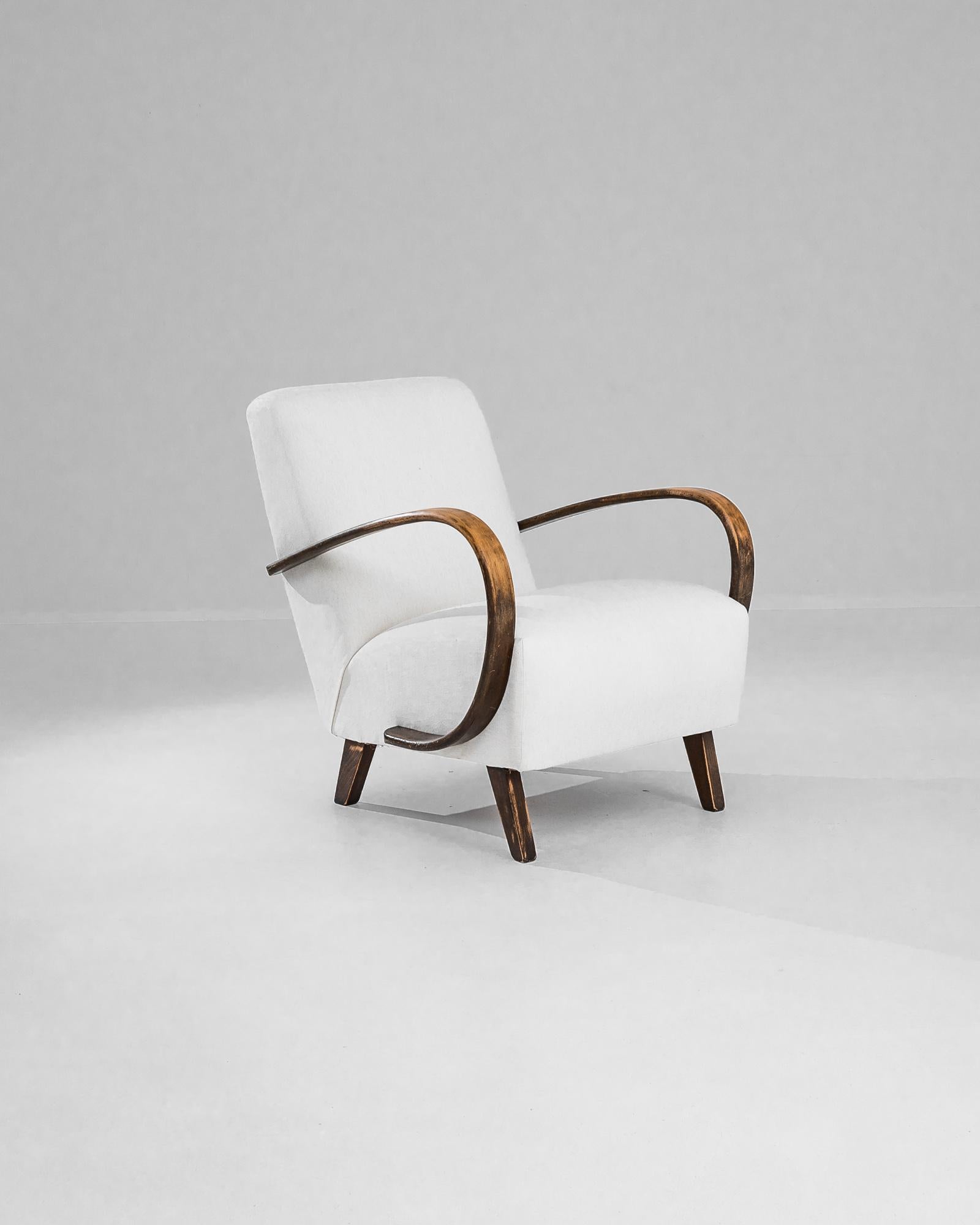Plongez dans le charme du design du milieu du siècle avec ce fauteuil tapissé tchèque des années 1950 du légendaire J. Halabala. Ce fauteuil est doté d'accoudoirs et de pieds en bois gracieusement incurvés qui témoignent du savoir-faire et de